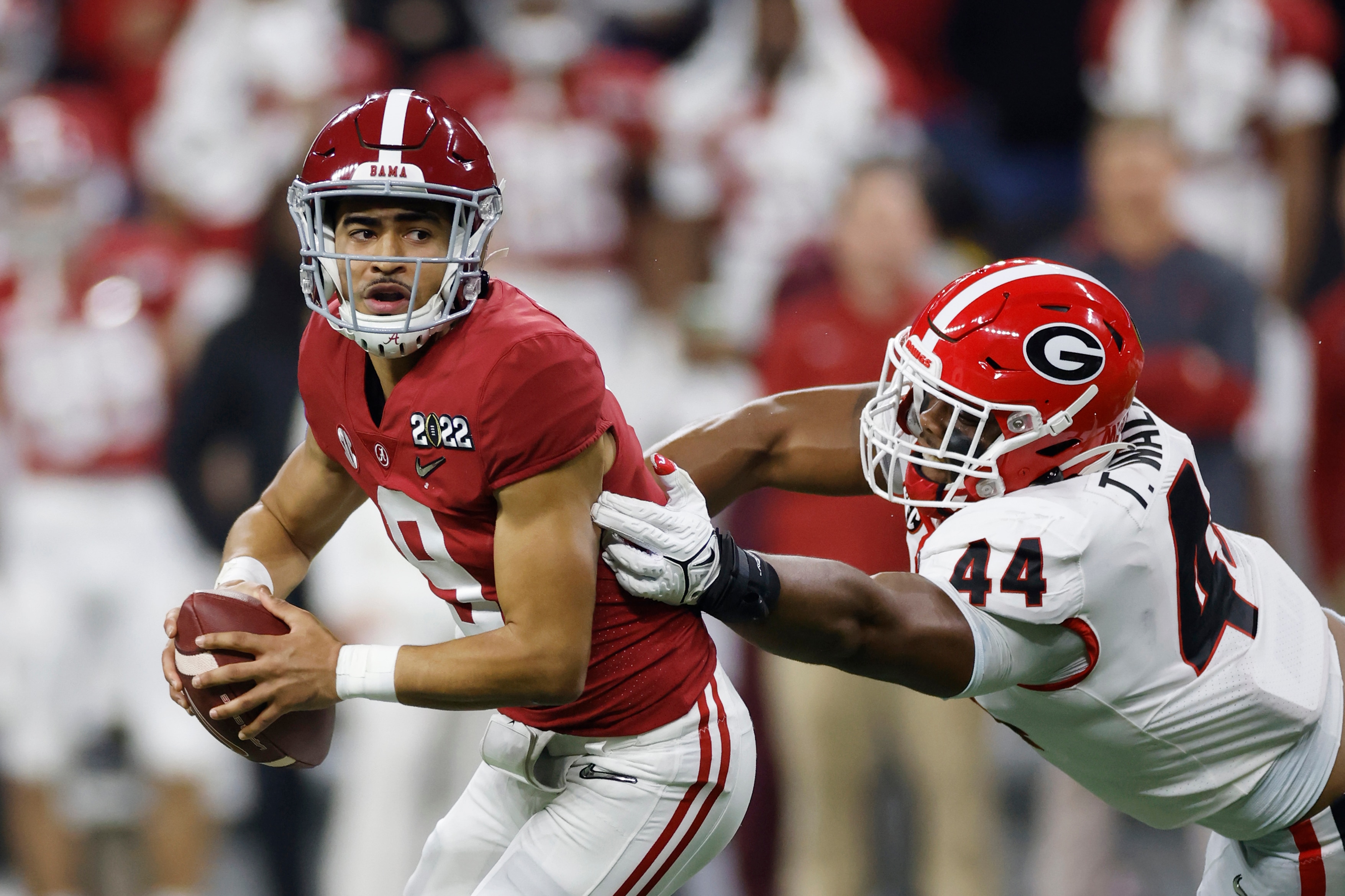 INDIANAPOLIS, IN - JANUARY 10: Alabama Crimson Tide quarterback Bryce Young (9) evades pressure from Georgia Bulldogs defensive lineman Travon Walker (44) while trying to pass during the CFP National Championship college football game on Jan. 10, 2022 at Lucas Oil Stadium in Indianapolis, Indiana. (Photo by Joe Robbins/Icon Sportswire via Getty Images)