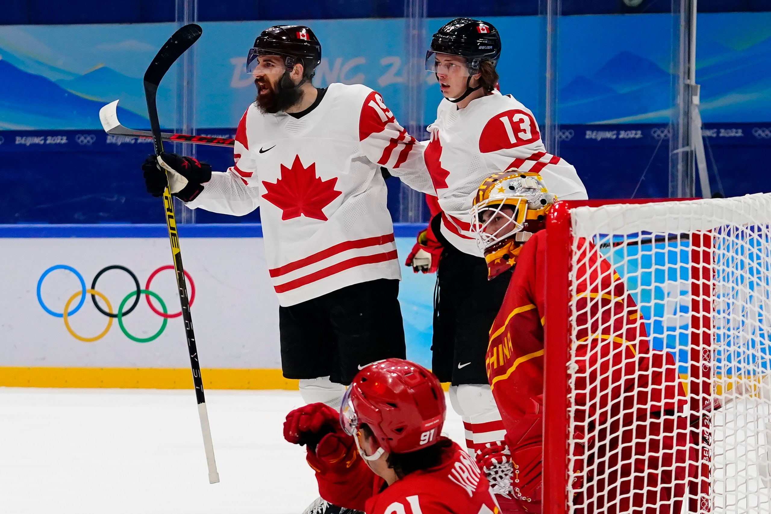 Canada's Eric O'Dell (19) celebrates with Kent Johnson (13) after scoring a goal during a preliminary round men's hockey game against China at the 2022 Winter Olympics, Sunday, Feb. 13, 2022, in Beijing. (AP Photo/Matt Slocum)