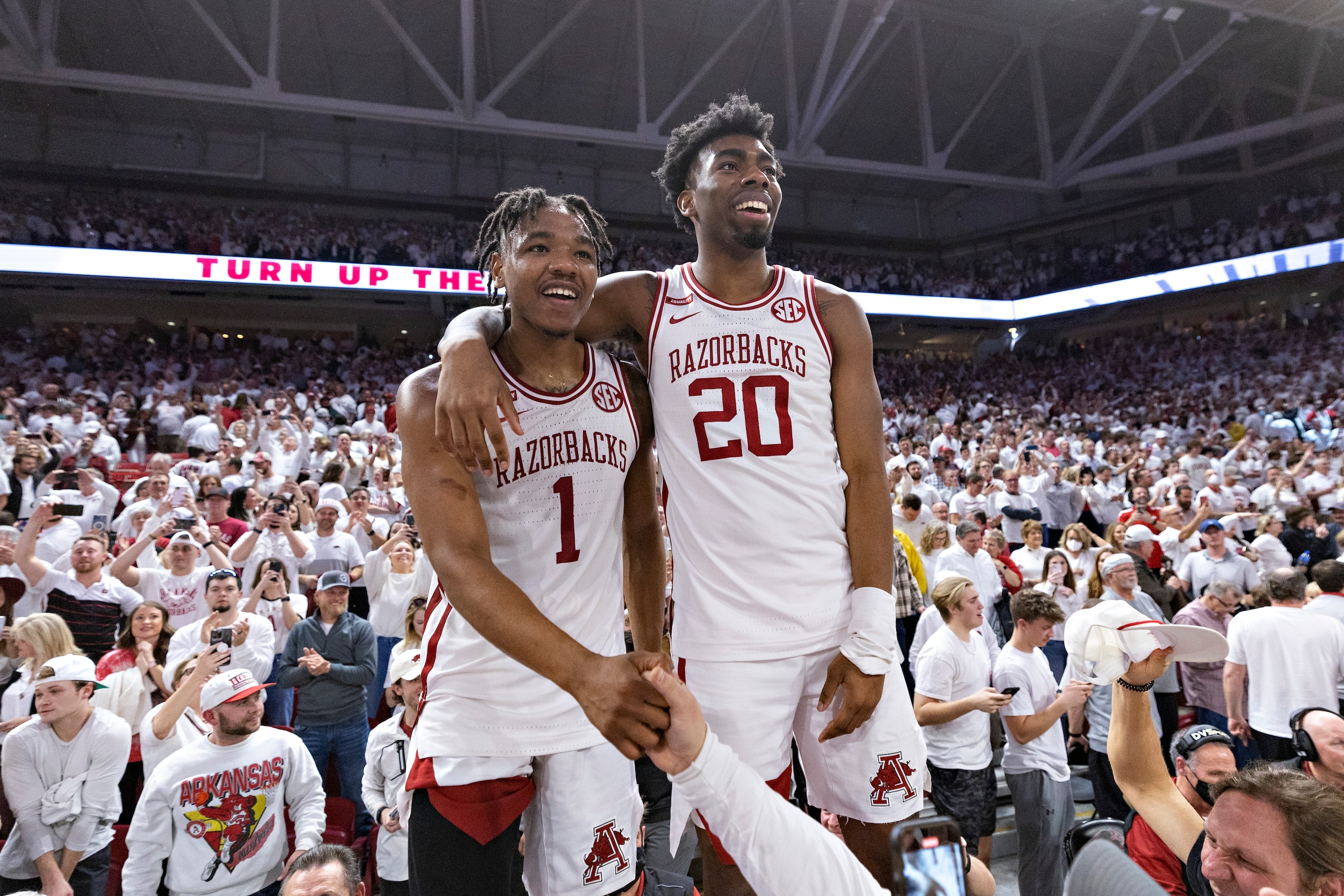 FAYETTEVILLE, ARKANSAS - FEBRUARY 08: JD Notae #1 and Kamani Johnson #20 of the Arkansas  Razorbacks celebrate after a win in overtime against the Auburn Tigers at Bud Walton Arena on February 08, 2022 in Fayetteville, Arkansas. The Razorbacks defeated the Tigers 80-76.  (Photo by Wesley Hitt/Getty Images)