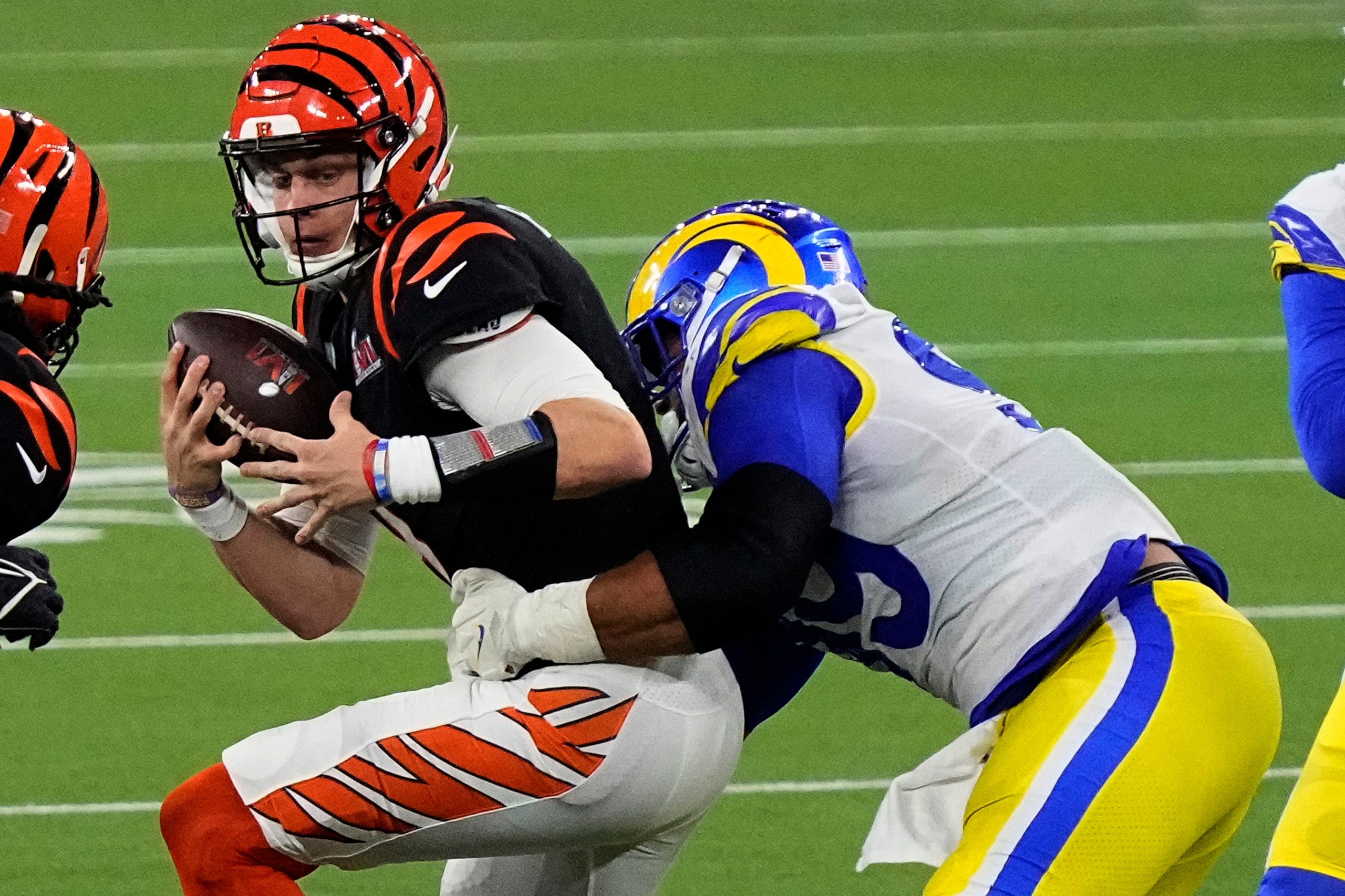 Los Angeles Rams defensive end Aaron Donald (99) tackles Cincinnati Bengals quarterback Joe Burrow (9) during the second half of the NFL Super Bowl 56 football game Sunday, Feb. 13, 2022, in Inglewood, Calif. The Los Angeles Rams won 23-20. (AP Photo/Ted S. Warren)