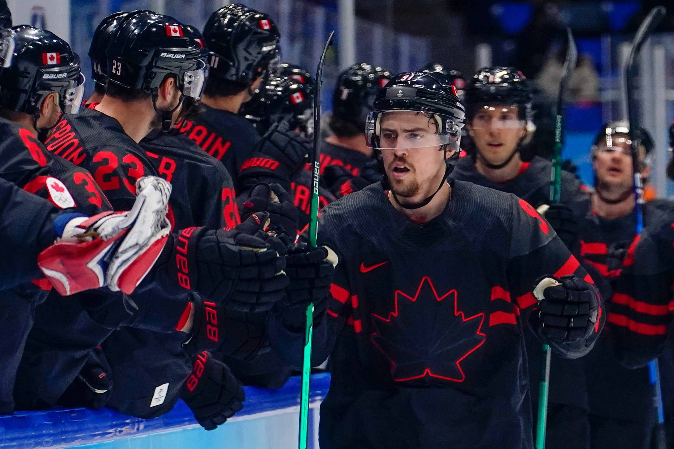Canada's Jordan Weal (91) is congratulated after scoring his second goal of a men's qualification round hockey game against China at the 2022 Winter Olympics, Tuesday, Feb. 15, 2022, in Beijing. (AP Photo/Matt Slocum)