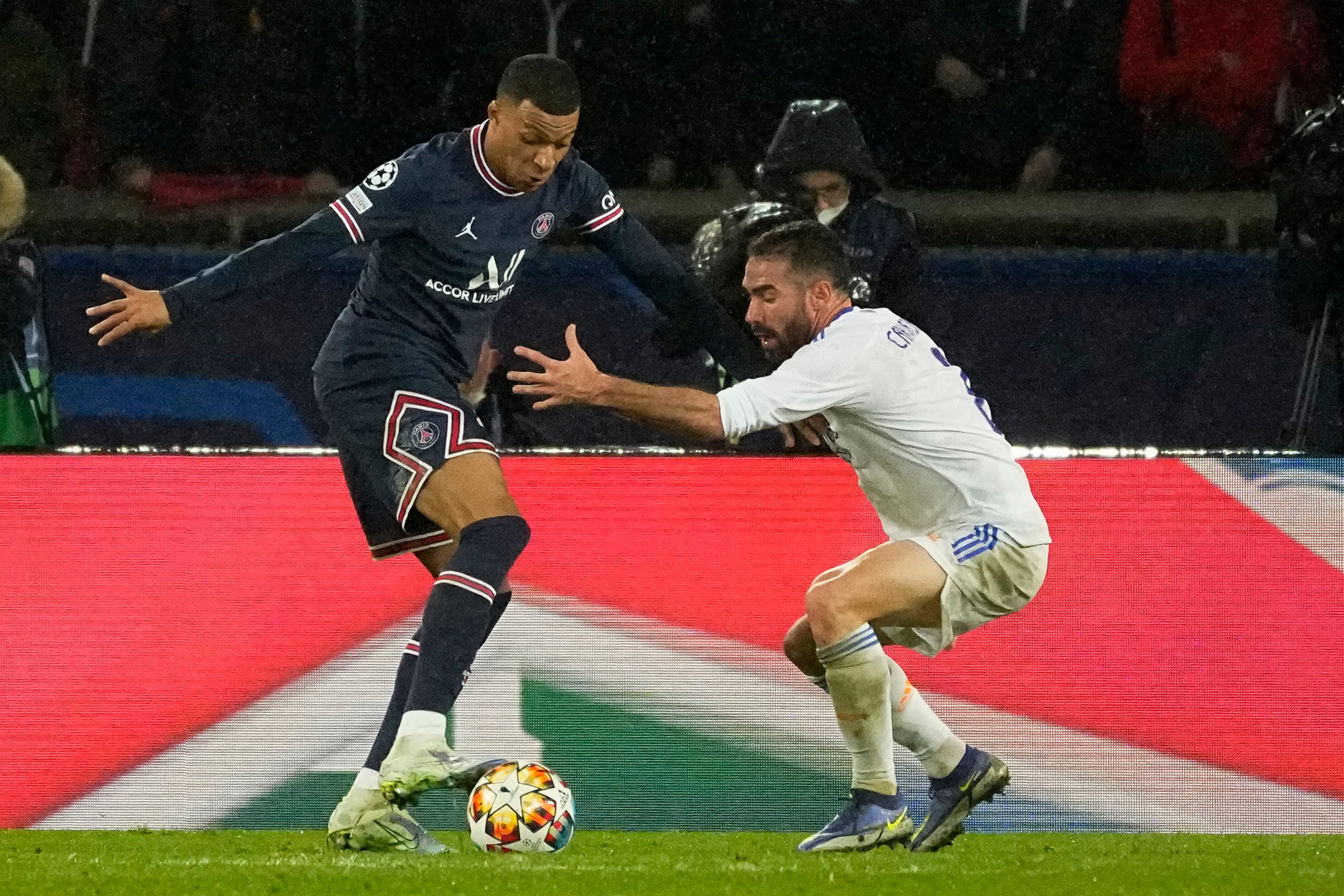 PSG's Kylian Mbappe, left, dribbles Real Madrid's Dani Carvajal during the Champions League round of 16, first leg, soccer match Paris Saint-Germain against Real Madrid at the Parc des Princes stadium in Paris, Tuesday, Feb.15, 2022. (AP Photo/Michel Euler)