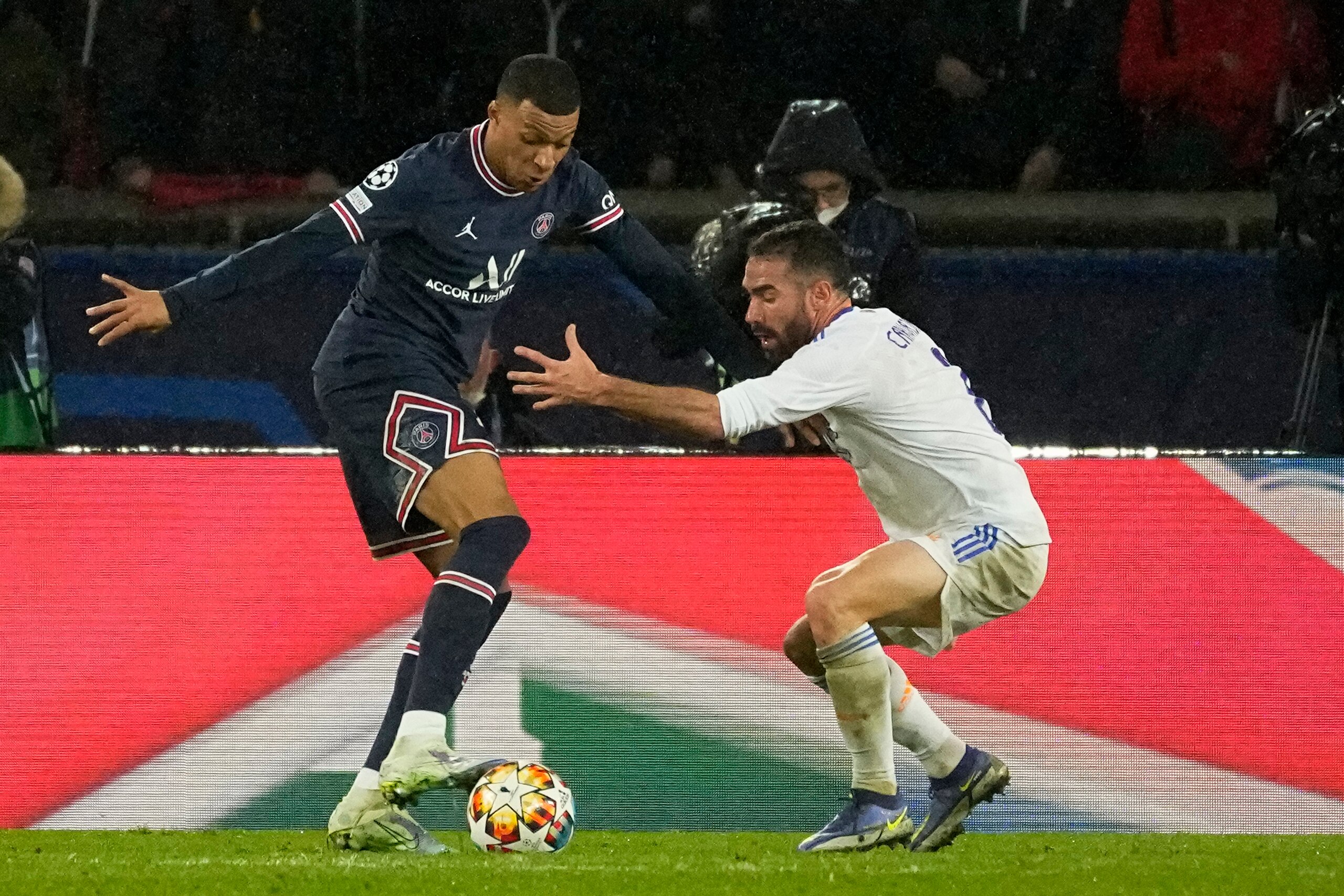 PSG's Kylian Mbappe, left, dribbles Real Madrid's Dani Carvajal during the Champions League round of 16, first leg, soccer match Paris Saint-Germain against Real Madrid at the Parc des Princes stadium in Paris, Tuesday, Feb.15, 2022. (AP Photo/Michel Euler)