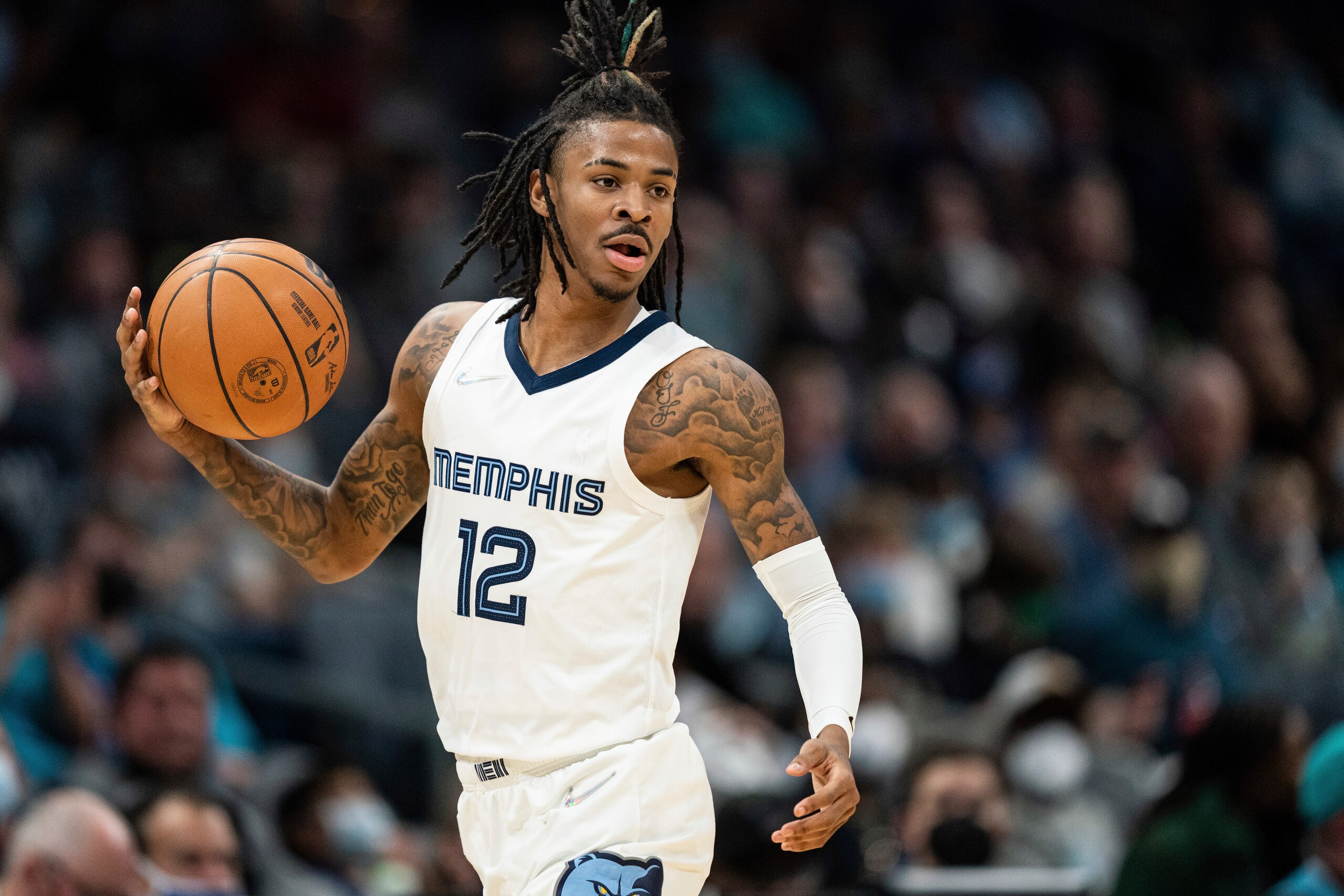 Memphis Grizzlies guard Ja Morant (12) brings the ball up court against the Charlotte Hornets during the first half of an NBA basketball game in Charlotte, N.C., Saturday, Feb. 12, 2022. (AP Photo/Jacob Kupferman)