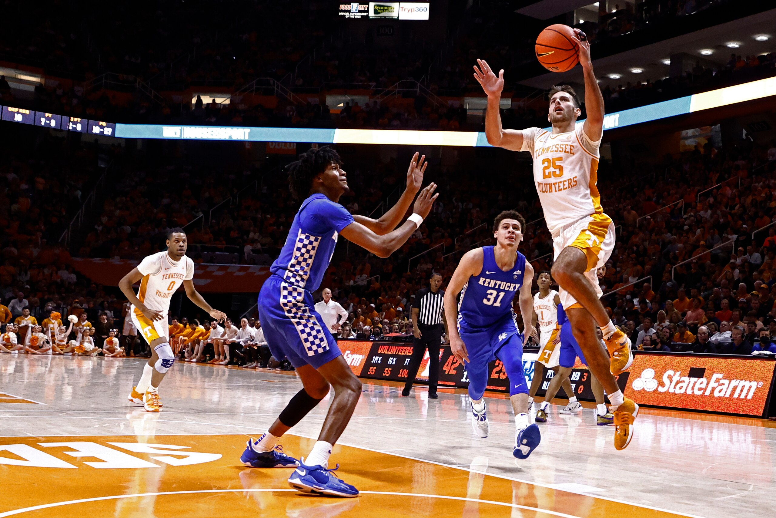 Tennessee guard Santiago Vescovi (25) shoots a layup past Kentucky guard Sahvir Wheelerand guard Kellan Grady (31) during the first half of an NCAA college basketball game Tuesday, Feb. 15, 2022, in Knoxville, Tenn. (AP Photo/Wade Payne)