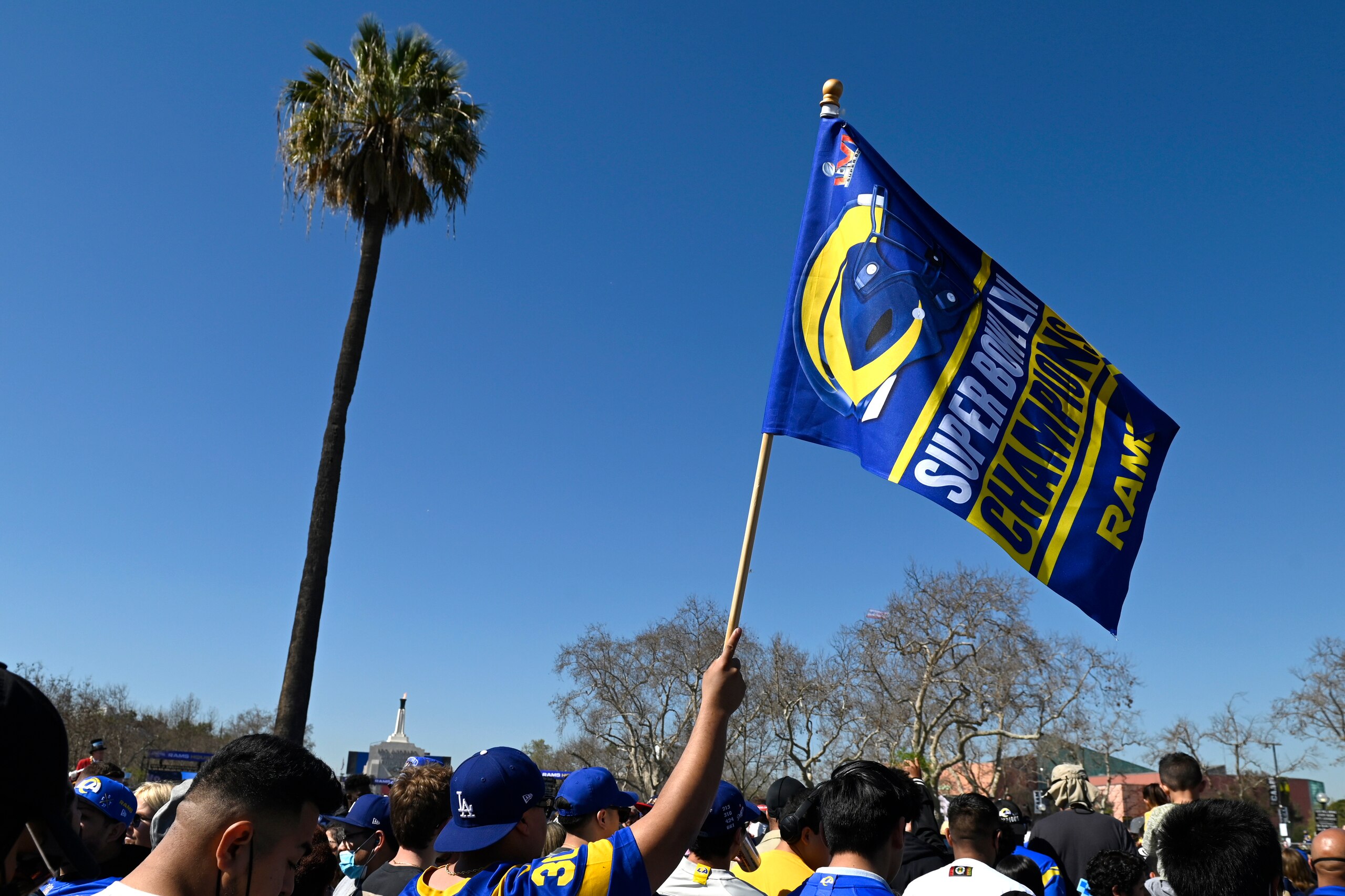 A fan waves a flag during the Los Angeles Rams' victory parade in Los Angeles, Wednesday, Feb. 16, 2022, following the Rams' win Sunday over the Cincinnati Bengals in the NFL Super Bowl 56 football game. (AP Photo/Kyusung Gong)
