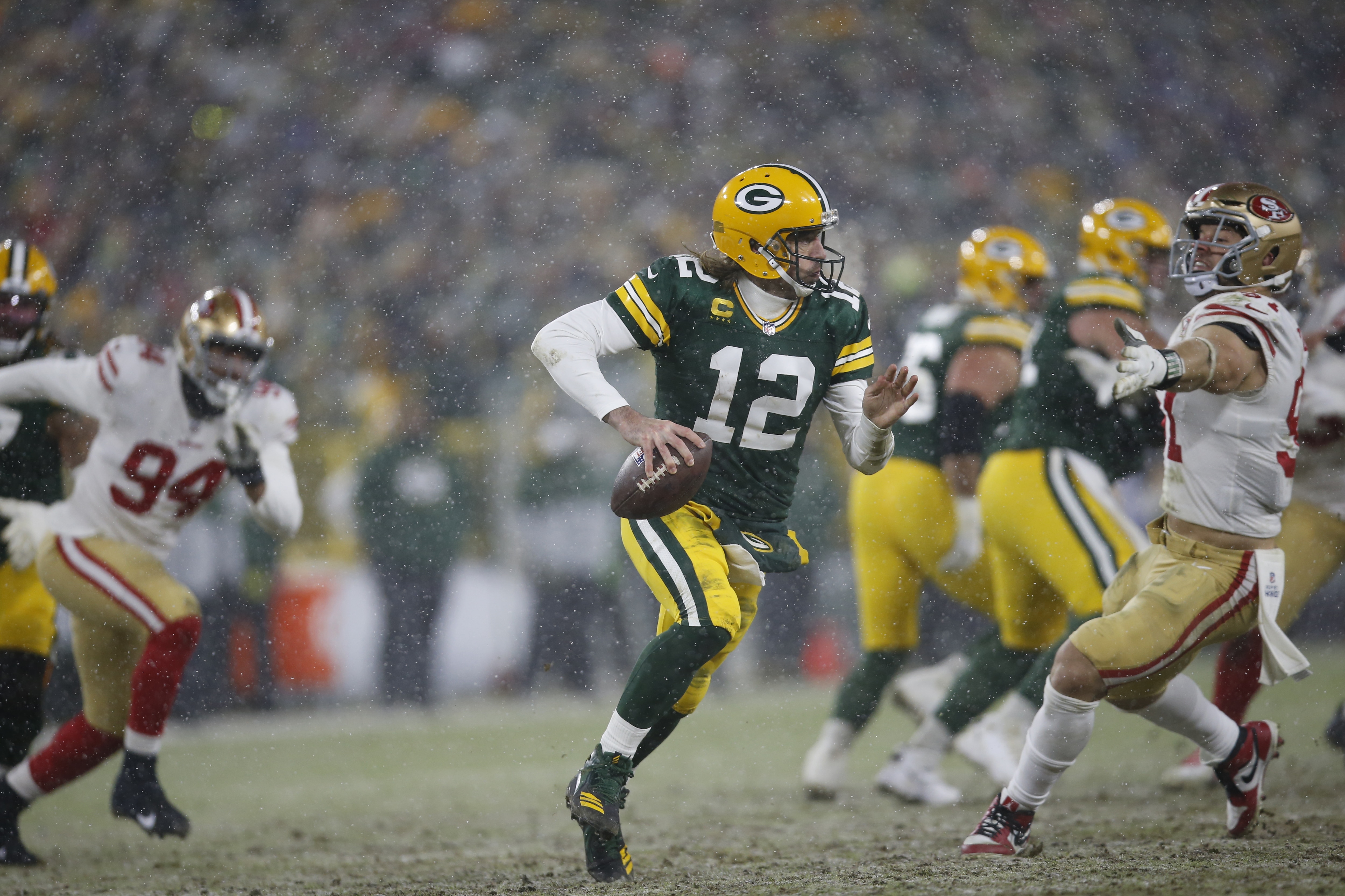 GREEN BAY, WISCONSIN - JANUARY 22: Aaron Rodgers #12 of the Green Bay Packers scrambles during the game against the San Francisco 49ers in the NFC Divisional Playoff game at Lambeau Field on January 22, 2022 in Green Bay, Wisconsin. The 49ers defeated the Packers 13-10. (Photo by Michael Zagaris/San Francisco 49ers/Getty Images)