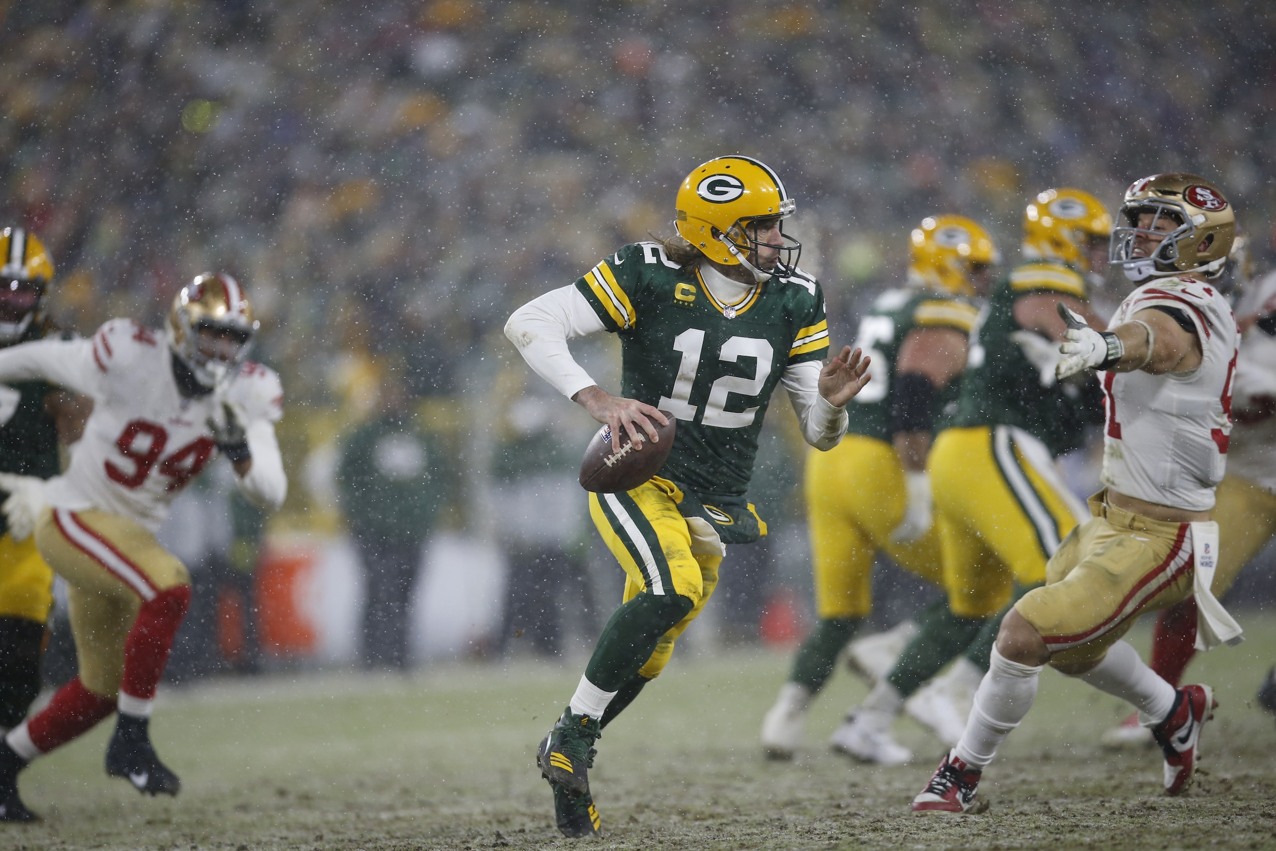 GREEN BAY, WISCONSIN - JANUARY 22: Aaron Rodgers #12 of the Green Bay Packers scrambles during the game against the San Francisco 49ers in the NFC Divisional Playoff game at Lambeau Field on January 22, 2022 in Green Bay, Wisconsin. The 49ers defeated the Packers 13-10. (Photo by Michael Zagaris/San Francisco 49ers/Getty Images)