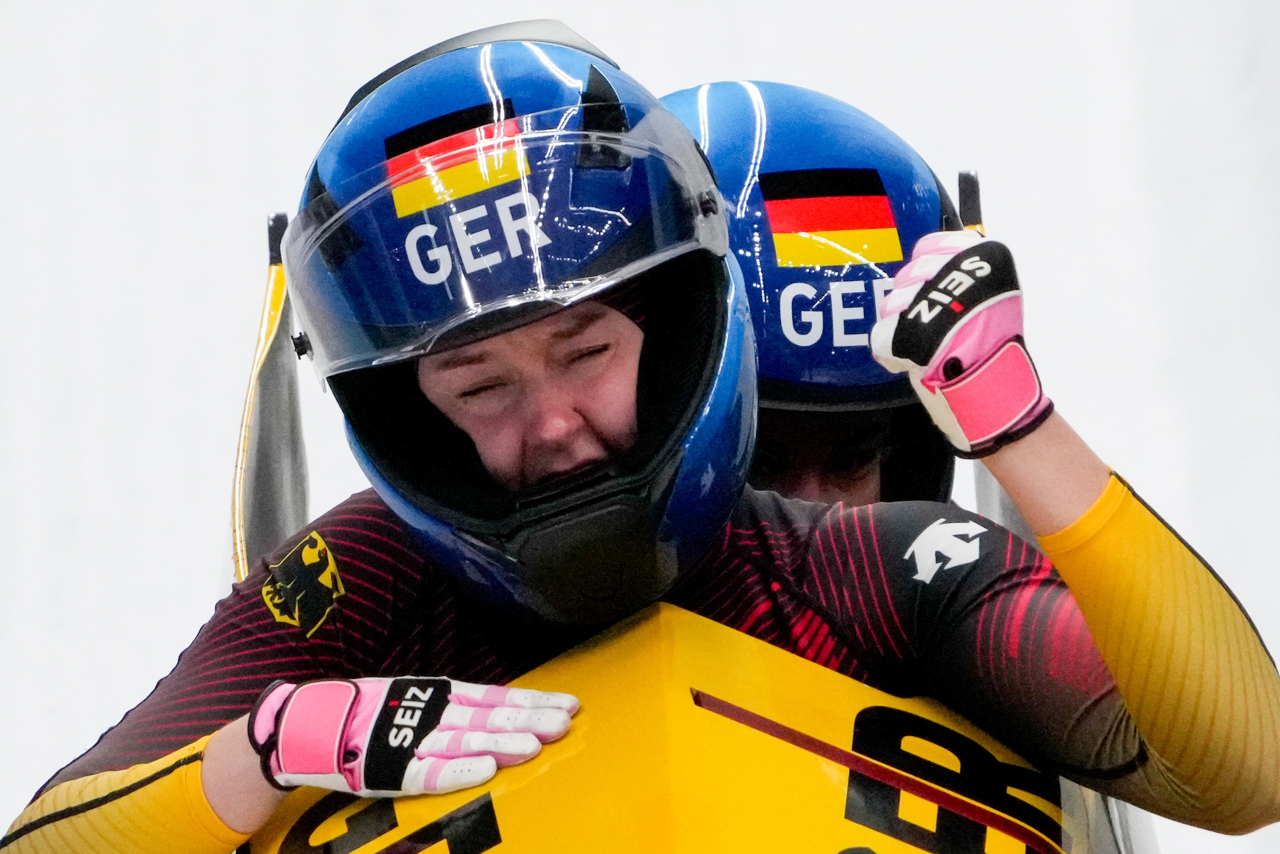 Laura Nolte and Deborah Levi, of Germany, celebrate winning the gold medal in the women's bobsleigh at the 2022 Winter Olympics, Saturday, Feb. 19, 2022, in the Yanqing district of Beijing. (AP Photo/Pavel Golovkin)