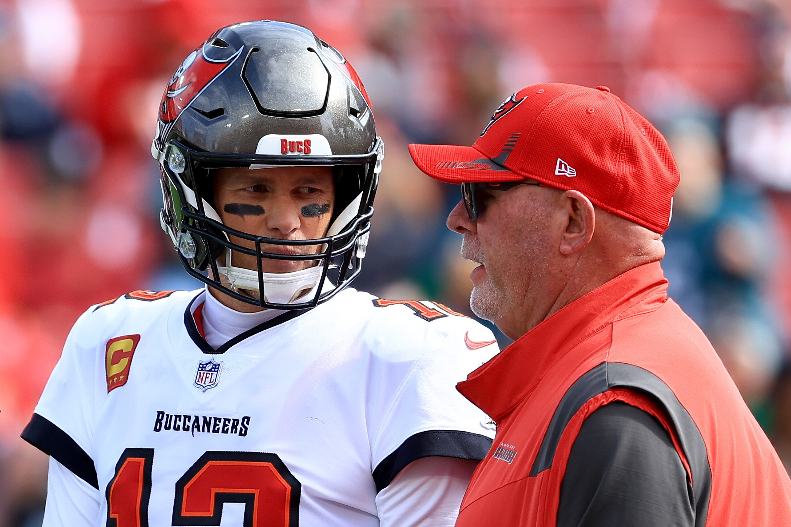 TAMPA, FLORIDA - JANUARY 16: Tom Brady #12 of the Tampa Bay Buccaneers talks with head coach Bruce Arians prior to the NFC Wild Card Playoff game against the Philadelphia Eagles at Raymond James Stadium on January 16, 2022 in Tampa, Florida. (Photo by Mike Ehrmann/Getty Images)