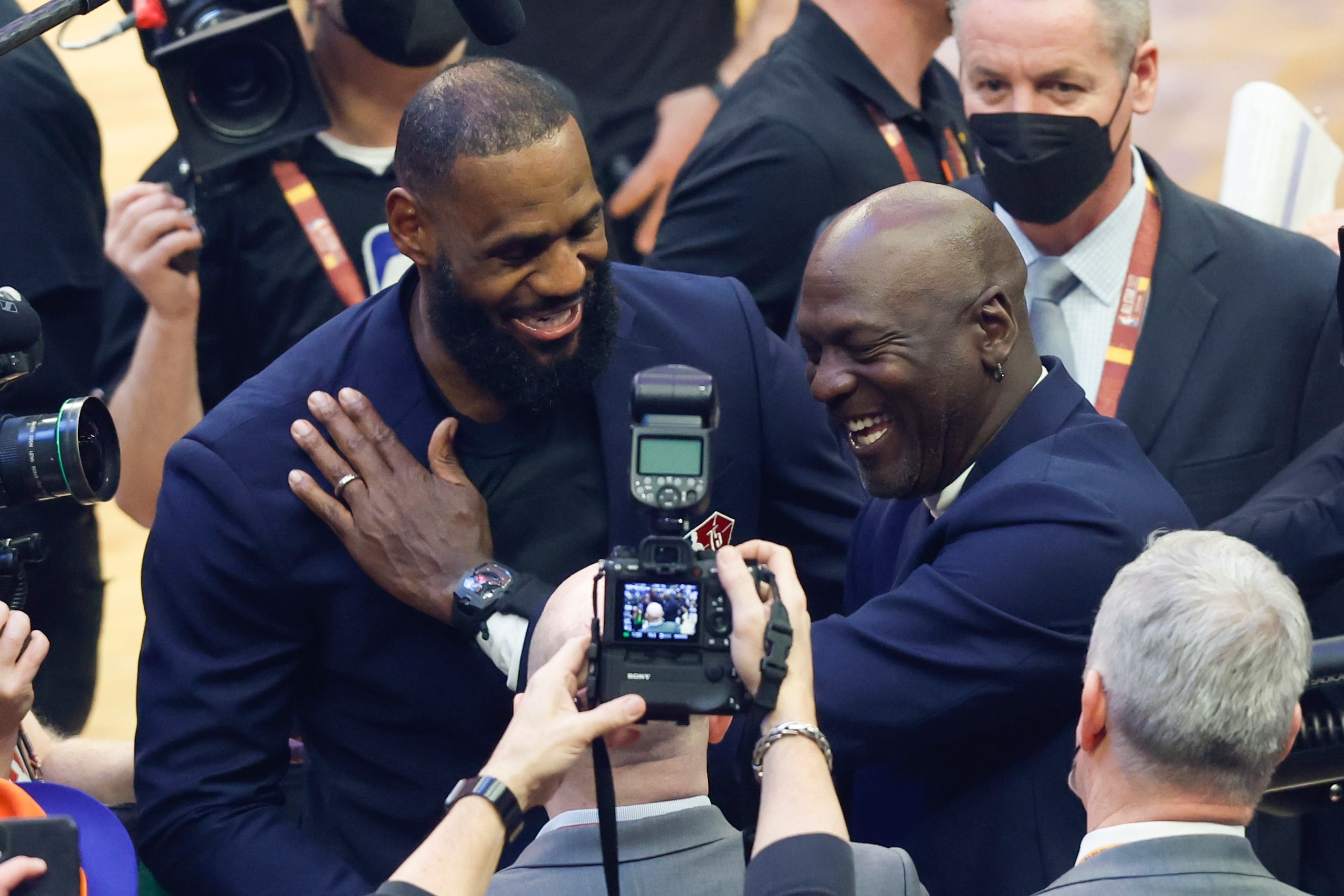 LeBron James, izquierda, de los Lakers de Los Ángeles y Michael Jordan, se saludan durante la introducción de los 75 jugadores más grandes durante el medio tiempo del Juego de Estrellas de la NBA, el domingo 20 de febrero de 2022, en Cleveland. (AP Foto/Ron Schwane)