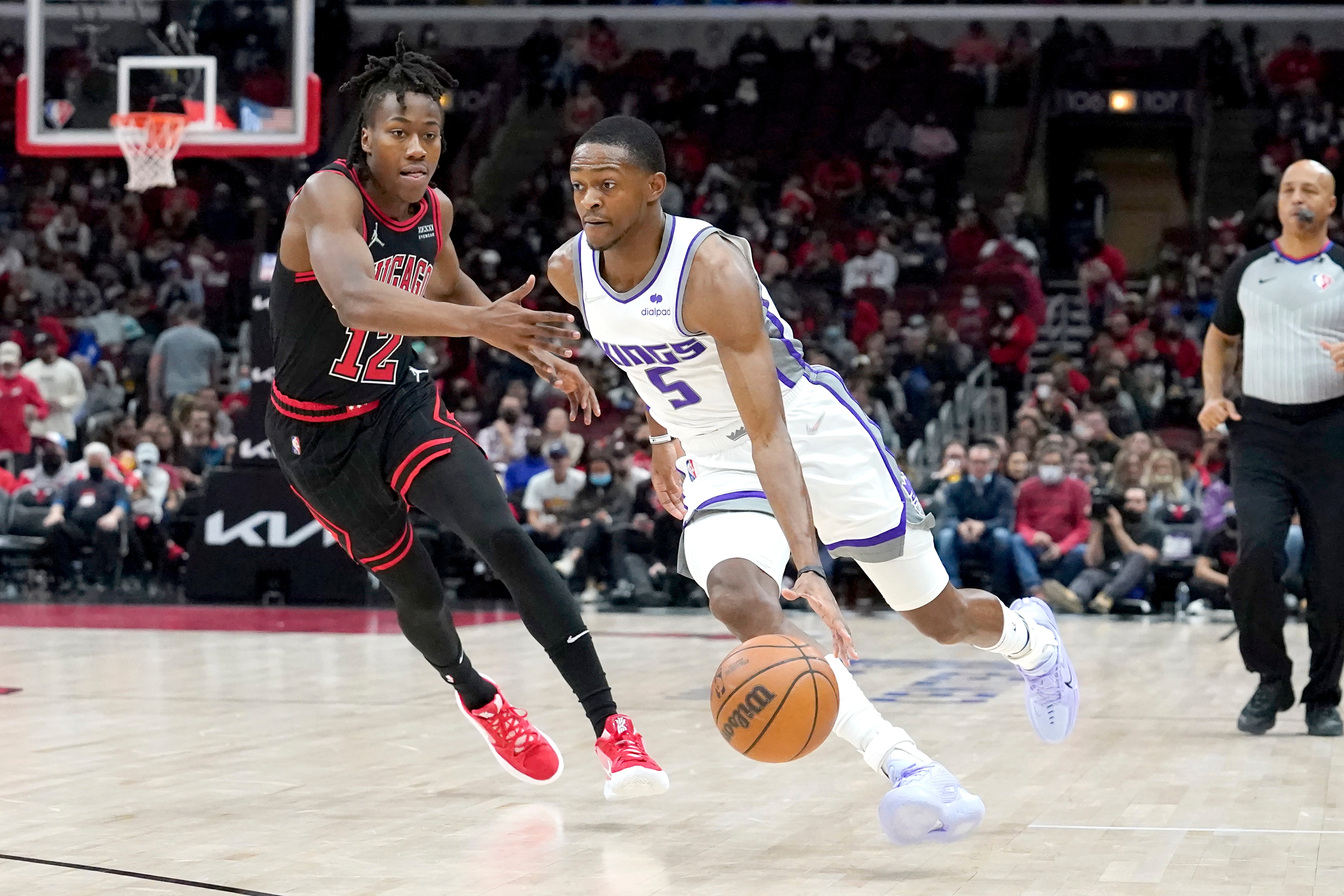 Sacramento Kings' De'Aaron Fox, right, drives on Chicago Bulls' Ayo Dosunmu during the first half of an NBA basketball game Wednesday, Feb. 16, 2022, in Chicago. (AP Photo/Charles Rex Arbogast)