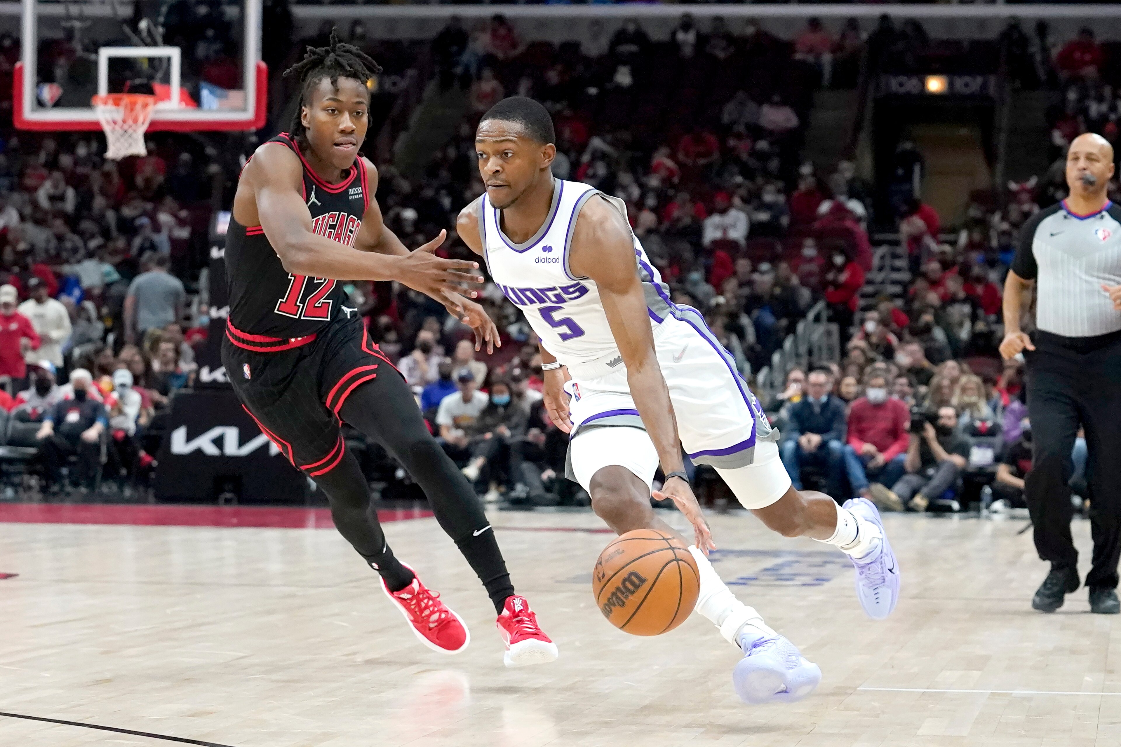 Sacramento Kings' De'Aaron Fox, right, drives on Chicago Bulls' Ayo Dosunmu during the first half of an NBA basketball game Wednesday, Feb. 16, 2022, in Chicago. (AP Photo/Charles Rex Arbogast)