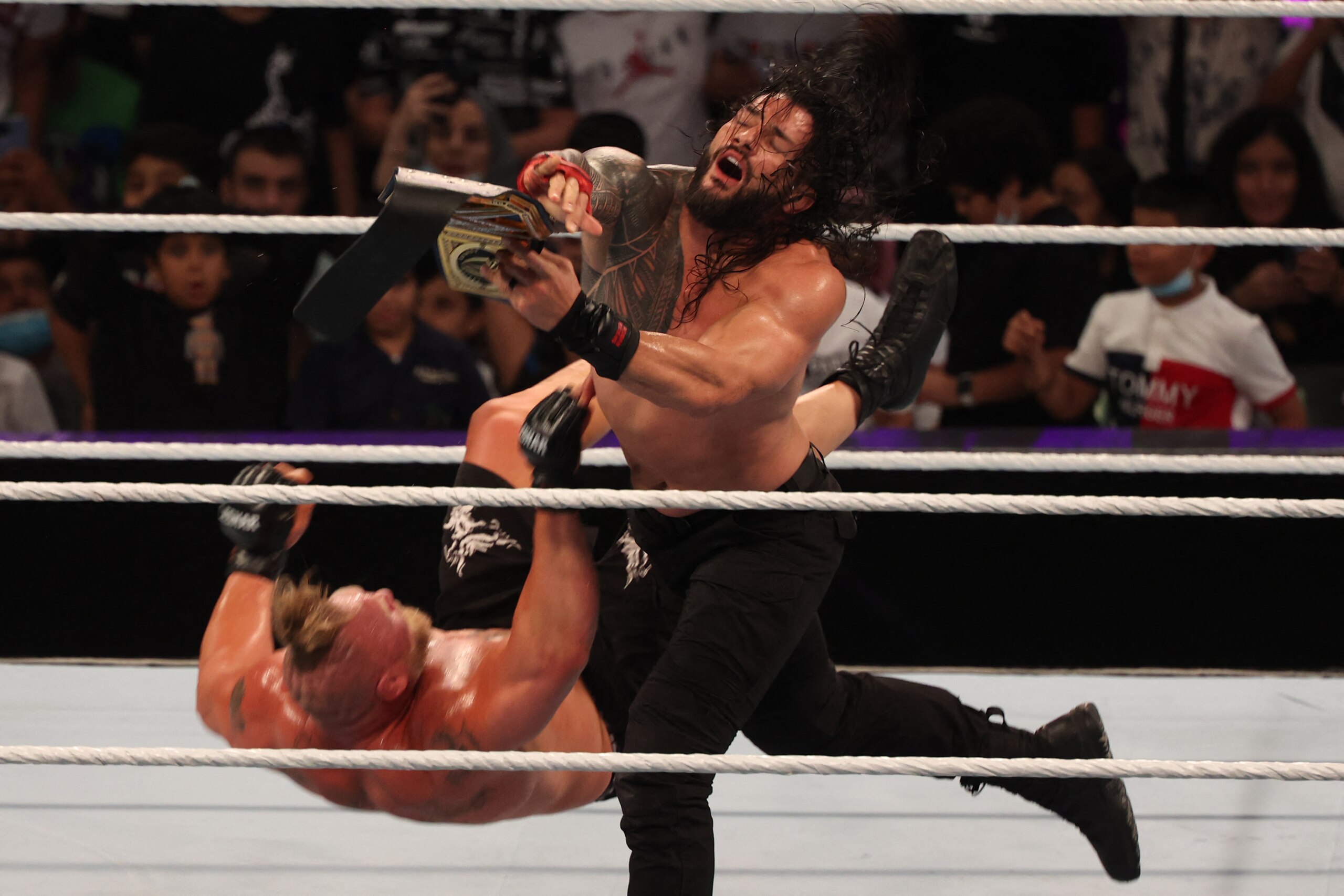 Roman Reigns (R) competes with Brock Lesnar during the World Wrestling Entertainment (WWE) Crown Jewel pay-per-view in the Saudi capital Riyadh on October 21, 2021. (Photo by Fayez Nureldine / AFP) (Photo by FAYEZ NURELDINE/AFP via Getty Images)