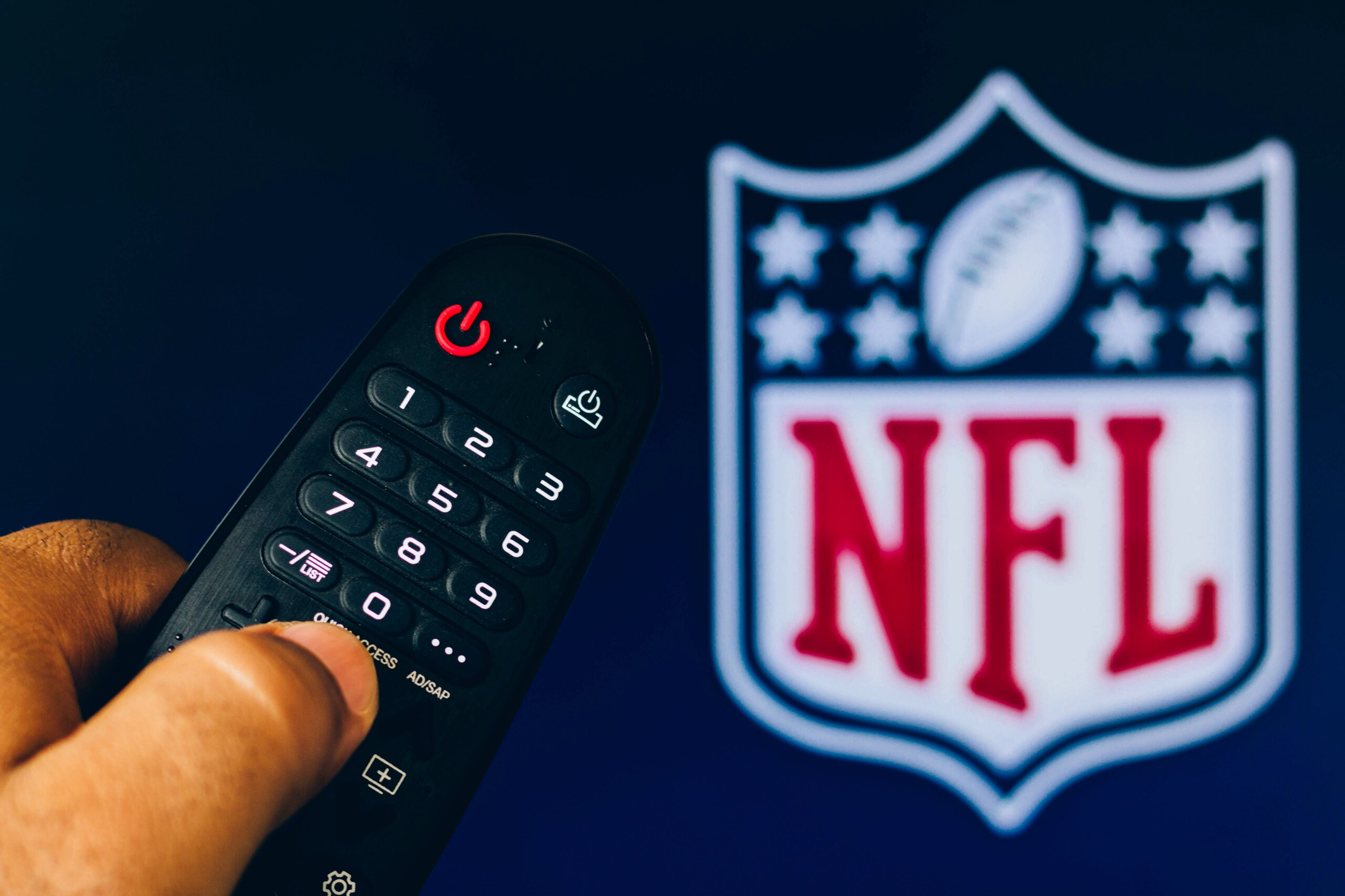 BRAZIL - 2022/02/21: In this photo illustration, a hand holding a TV remote control points to a screen that displays the NFL Network logo. (Photo Illustration by Rafael Henrique/SOPA Images/LightRocket via Getty Images)