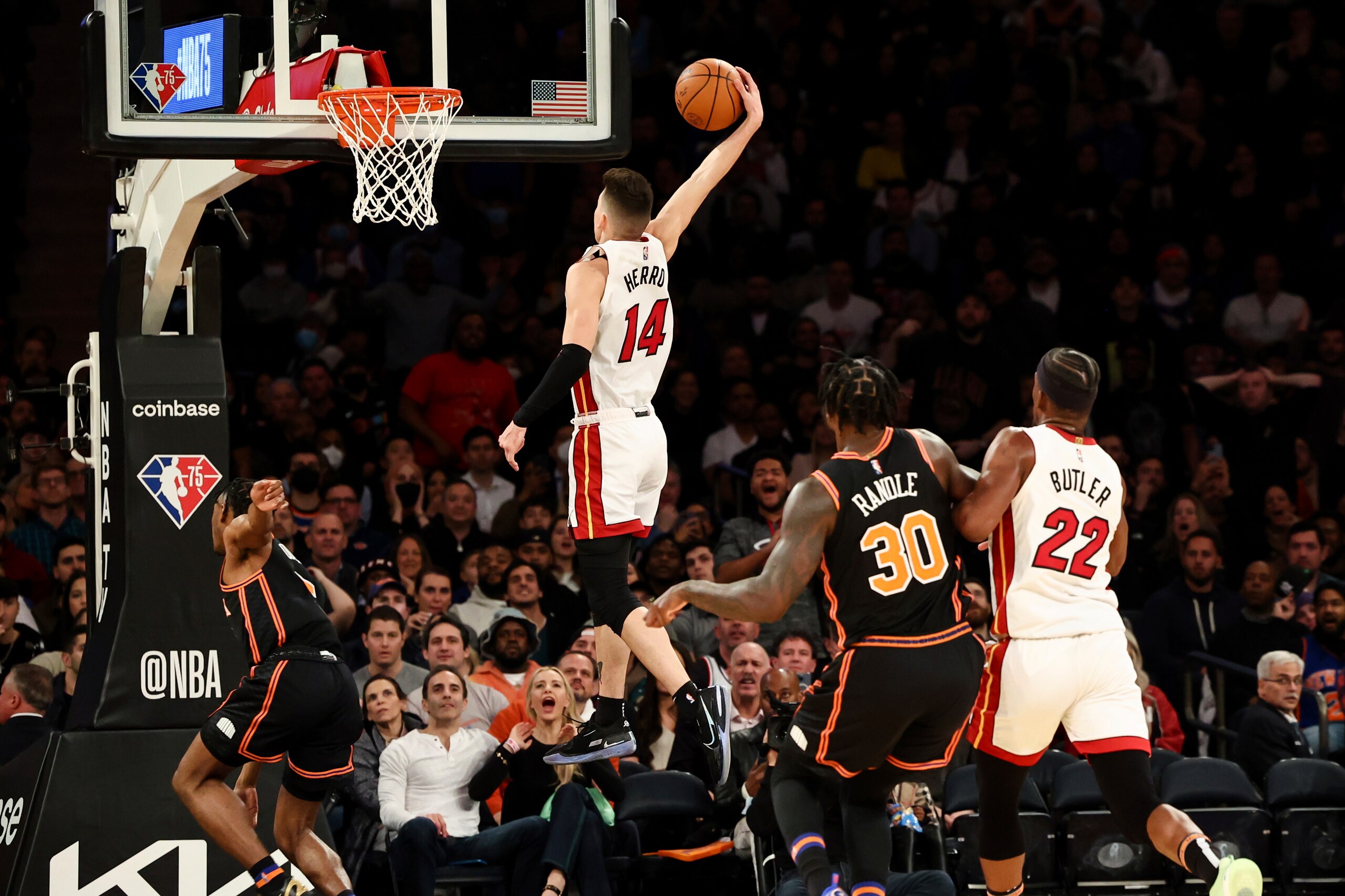 Miami Heat guard Tyler Herro (14) goes up to dunk as New York Knicks forward Julius Randle (30) and Heat forward Jimmy Butler (22) look on during the second half of an NBA basketball game, Friday, Feb. 25, 2022, in New York. (AP Photo/Jessie Alcheh)