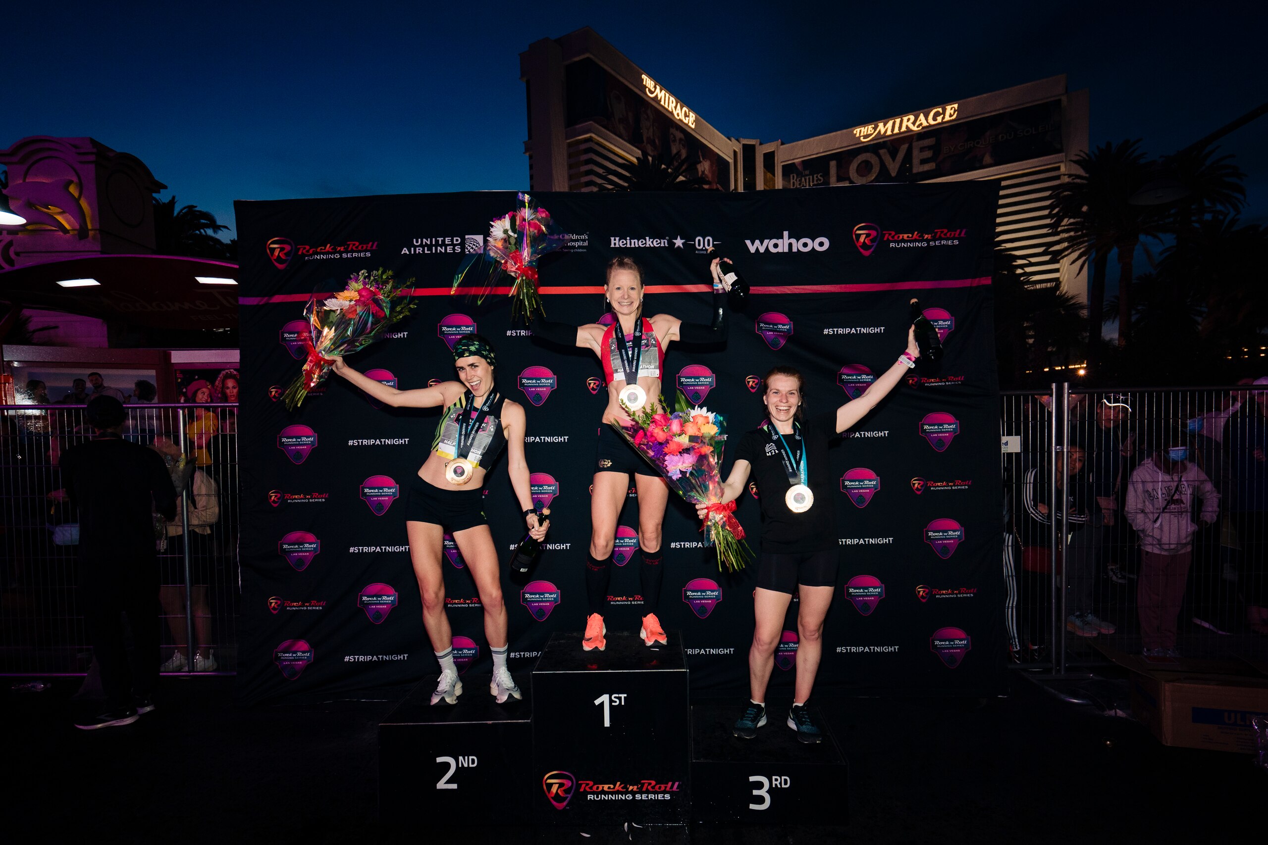 LAS VEGAS, NV - FEBRUARY 27: Ellie Stevens of Las Vegas, Danae Dracht of Santa Monica and Kirsten Lee of North Vancouver Canada celebrate coming the top three of the in the Rock 'n' Roll Half Marathon Run on February 27, 2022 in Las Vegas, Nevada. (Photo by Kyle Rivas/Getty Images for Rock 'n' Roll Marathon)
