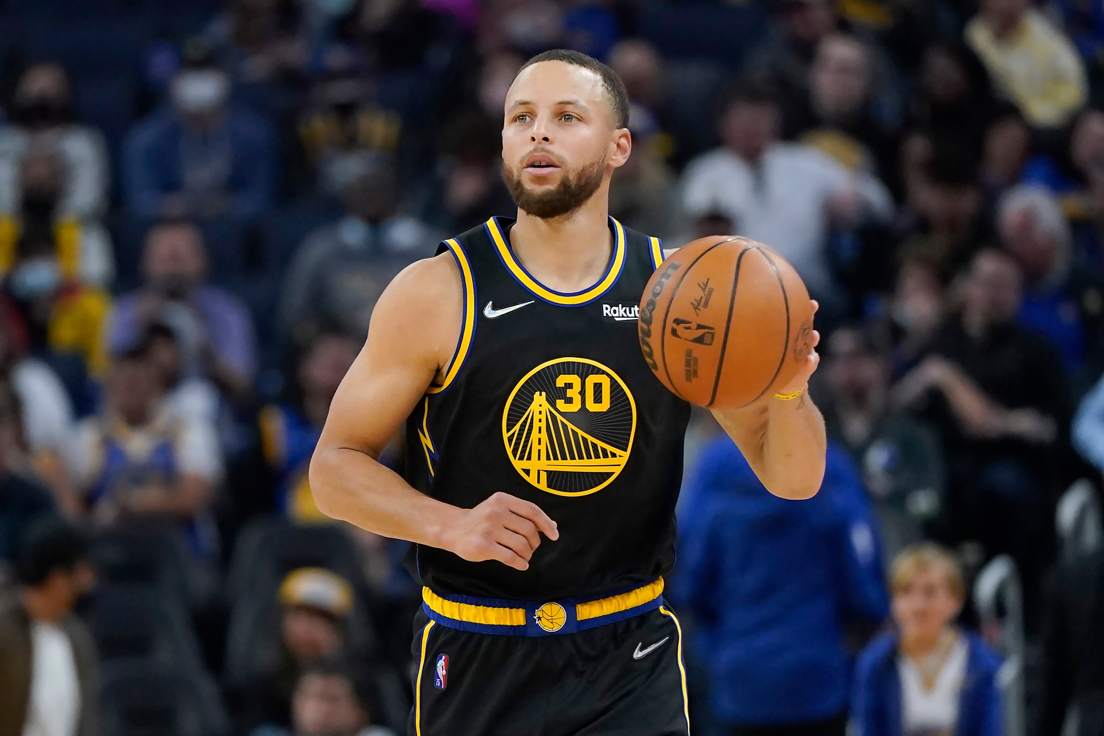 Golden State Warriors guard Stephen Curry dribbles the ball up the court against the Dallas Mavericks during the second half of an NBA basketball game in San Francisco, Sunday, Feb. 27, 2022. (AP Photo/Jeff Chiu)