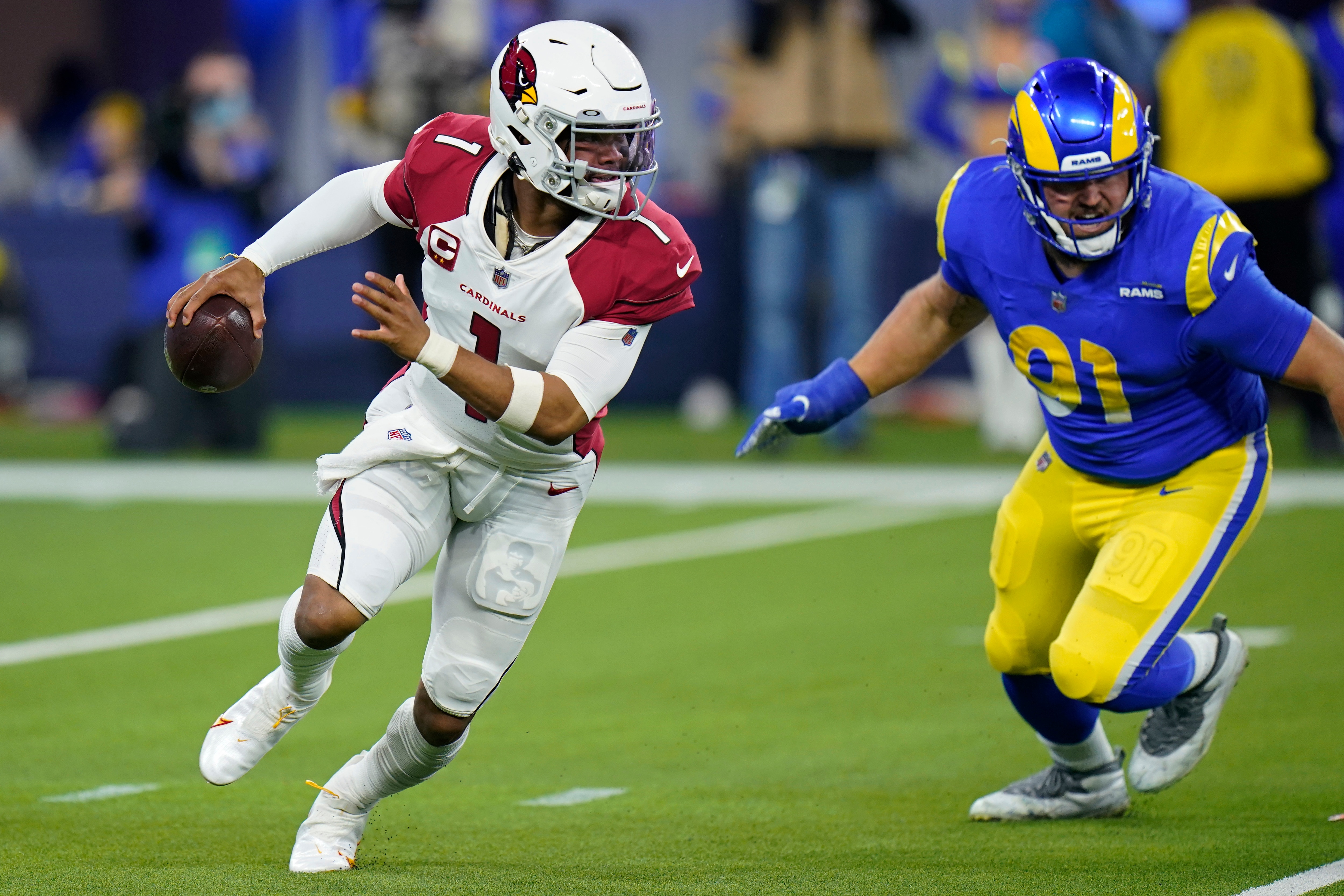Arizona Cardinals quarterback Kyler Murray (1) scrambles from Los Angeles Rams defensive end Greg Gaines (91) during the first half of an NFL wild-card playoff football game in Inglewood, Calif., Monday, Jan. 17, 2022. (AP Photo/Jae C. Hong)