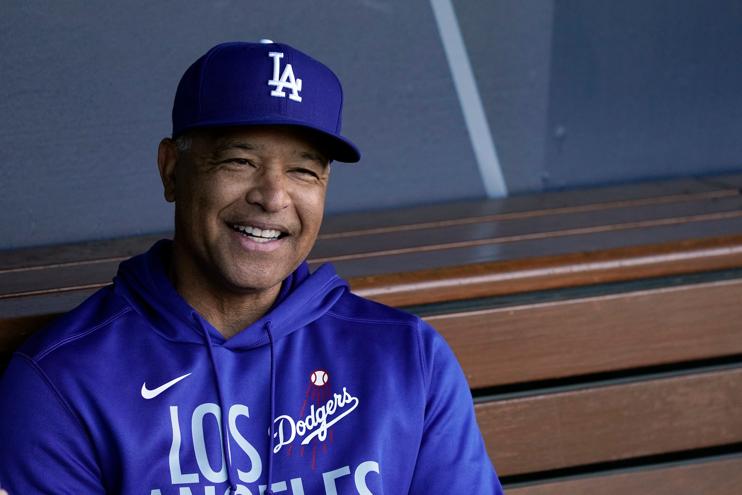 Los Angeles Dodgers manager Dave Roberts smiles in the dugout during a workout ahead of Game 3 of baseball's National League Championship Series against the Atlanta Braves, Monday, Oct. 18, 2021, in Los Angeles. (AP Photo/Marcio Jose Sanchez)