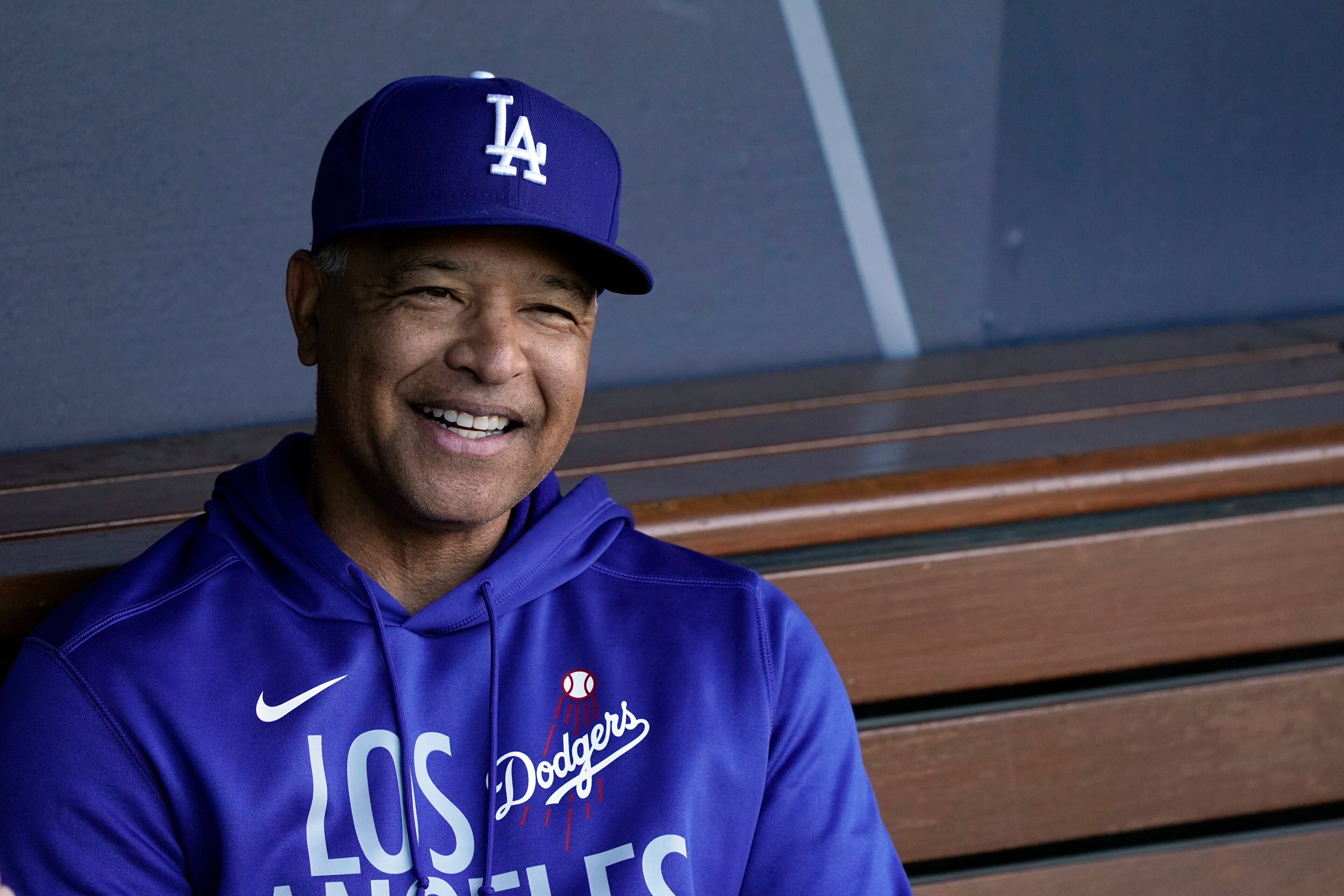 Los Angeles Dodgers manager Dave Roberts smiles in the dugout during a workout ahead of Game 3 of baseball's National League Championship Series against the Atlanta Braves, Monday, Oct. 18, 2021, in Los Angeles. (AP Photo/Marcio Jose Sanchez)
