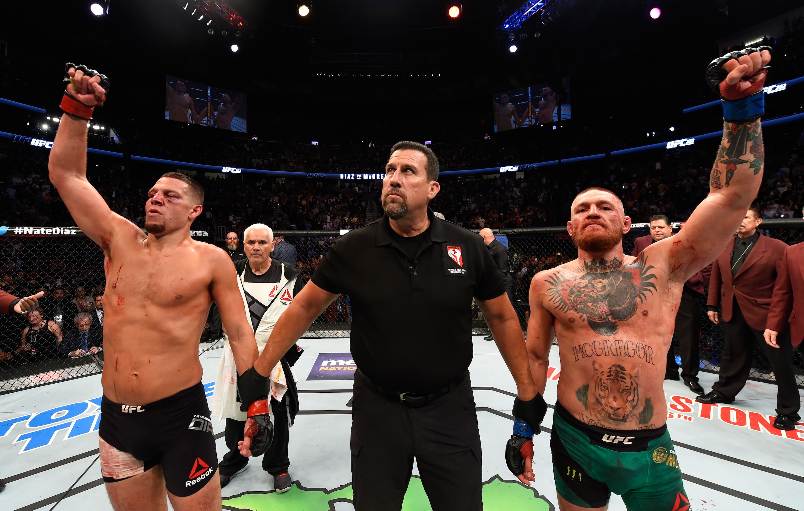 LAS VEGAS, NV - AUGUST 20:   (R-L) Conor McGregor of Ireland and Nate Diaz raise their hands and wait to hear the judges decision after their welterweight bout during the UFC 202 event at T-Mobile Arena on August 20, 2016 in Las Vegas, Nevada. (Photo by Josh Hedges/Zuffa LLC/Zuffa LLC via Getty Images)