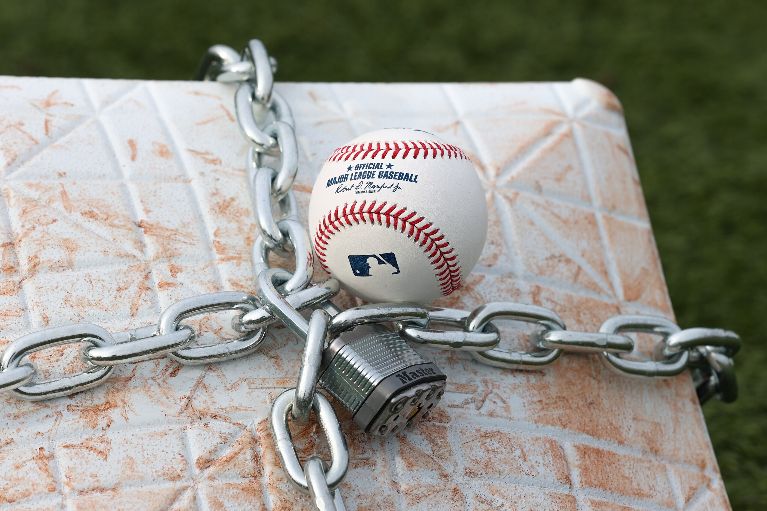 LINCROFT, NJ - JANUARY 28:  An official MLB baseball sits on top of an MLB game-used base with a lock and chain around it to represent the lockout between Major League Baseball (MLB) and the Major League Baseball Players Association (MLBPA) on January 28, 2022  in Lincroft, New Jersey.  (Photo by Rich Graessle/Icon Sportswire via Getty Images)