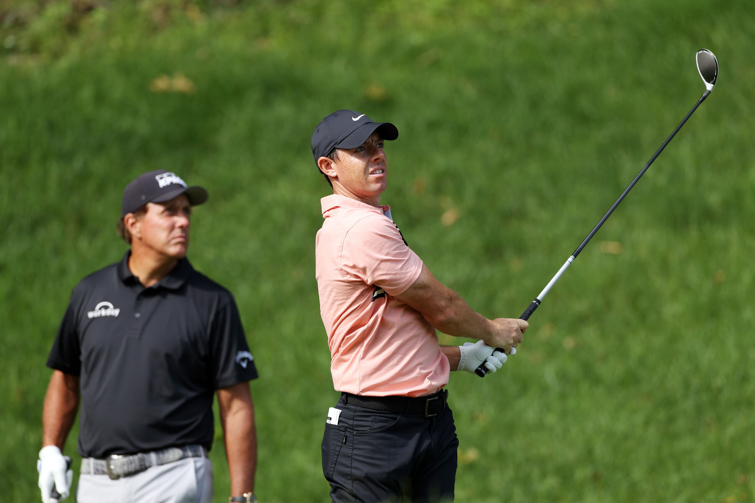 CROMWELL, CONNECTICUT - JUNE 25: Rory McIlroy of Northern Ireland plays his shot from the 15th tee as Phil Mickelson of the United States looks on during the first round of the Travelers Championship at TPC River Highlands on June 25, 2020 in Cromwell, Connecticut. (Photo by Rob Carr/Getty Images)