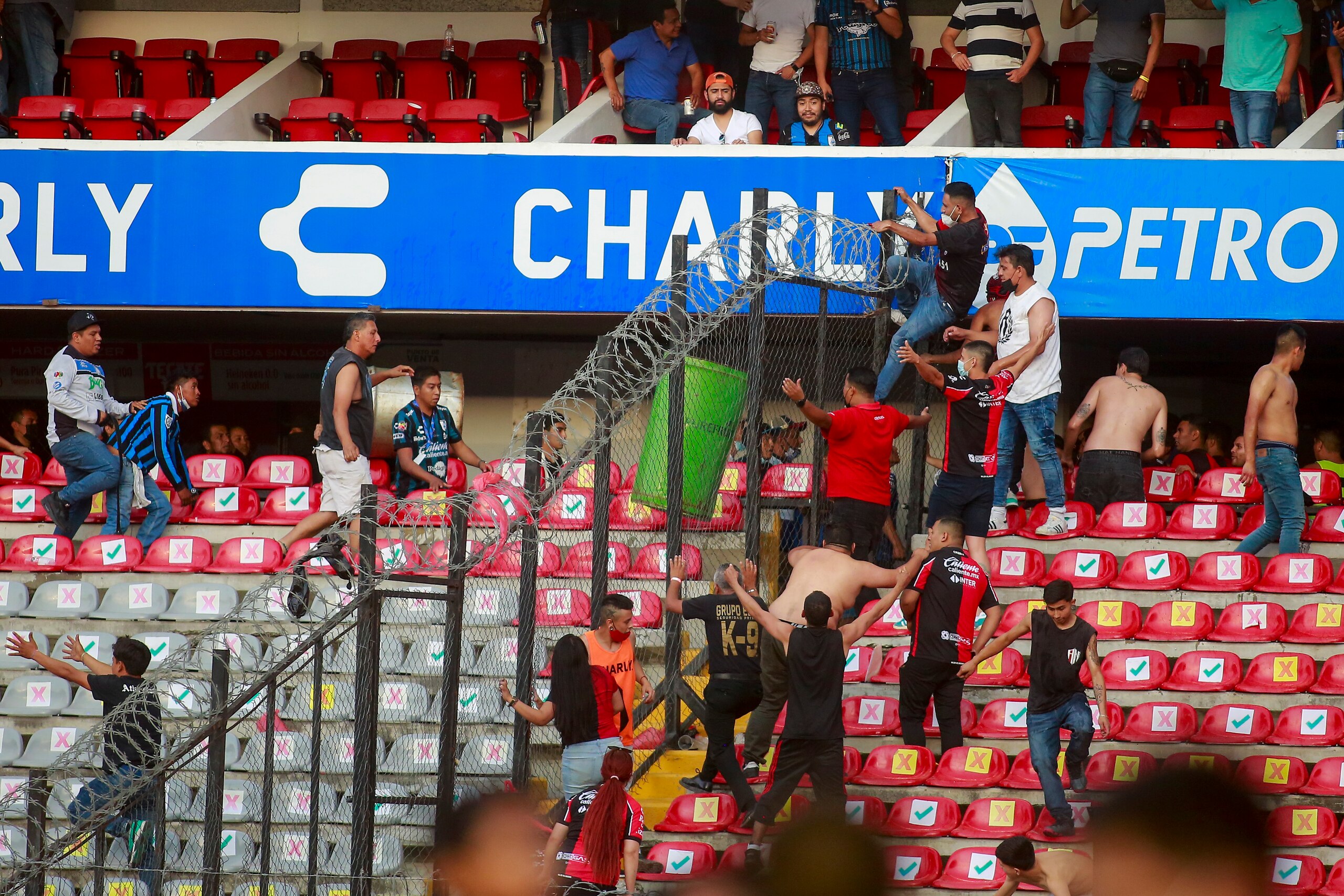 Fans of Queretaro and Atlas clash during a Mexican soccer league match at the Corregidora stadium, in Queretaro, Mexico, Saturday, March 5, 2022. The match was suspended after fans invaded the field. (AP Photo/Eduardo Gomez Reyna)