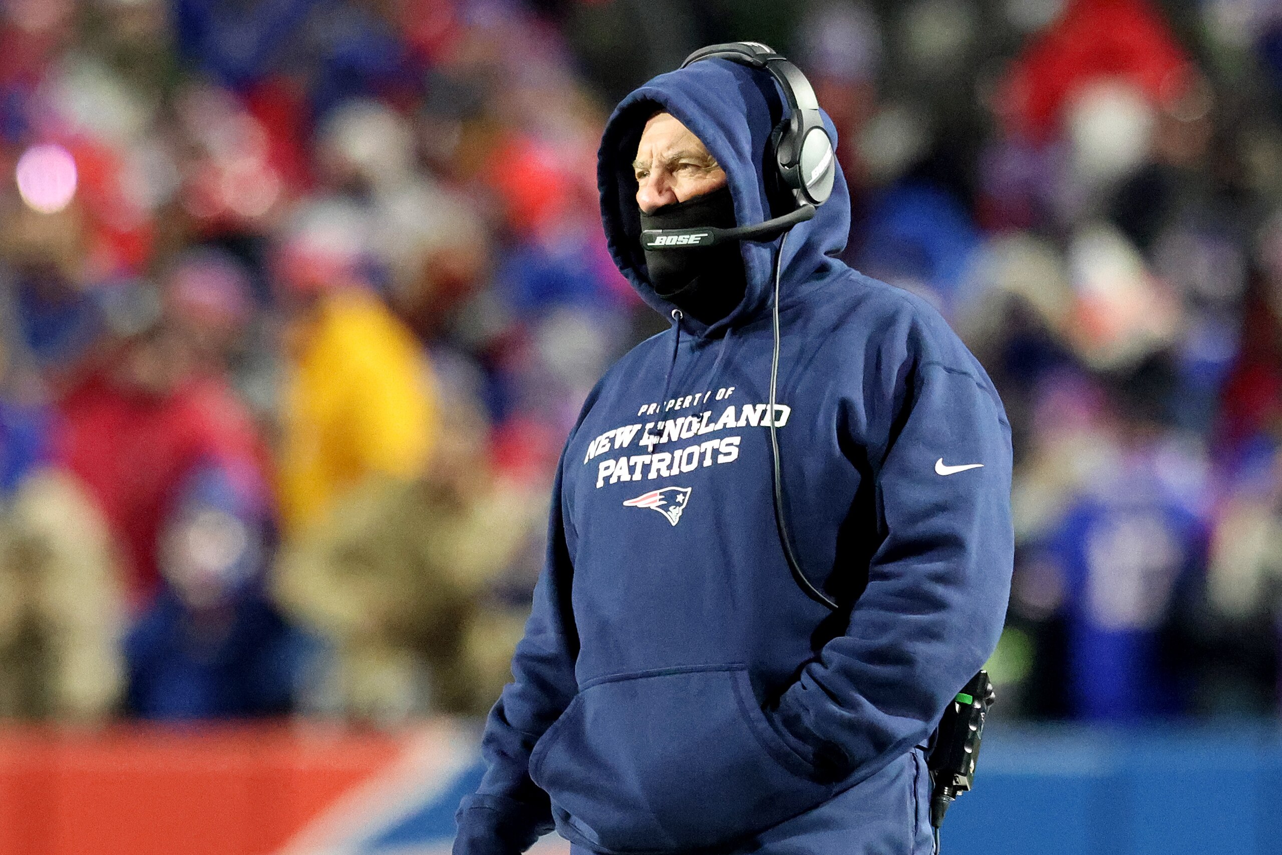BUFFALO, NEW YORK - JANUARY 15: Head coach Bill Belichick of the New England Patriots looks on against the Buffalo Bills during the first half in the AFC Wild Card playoff game at Highmark Stadium on January 15, 2022 in Buffalo, New York. (Photo by Bryan M. Bennett/Getty Images) BUFFALO, NEW YORK - JANUARY 15: Head coach Bill Belichick of the New England Patriots looks on against the Buffalo Bills during the first half in the AFC Wild Card playoff game at Highmark Stadium on January 15, 2022 in Buffalo, New York. (Photo by Bryan M. Bennett/Getty Images)