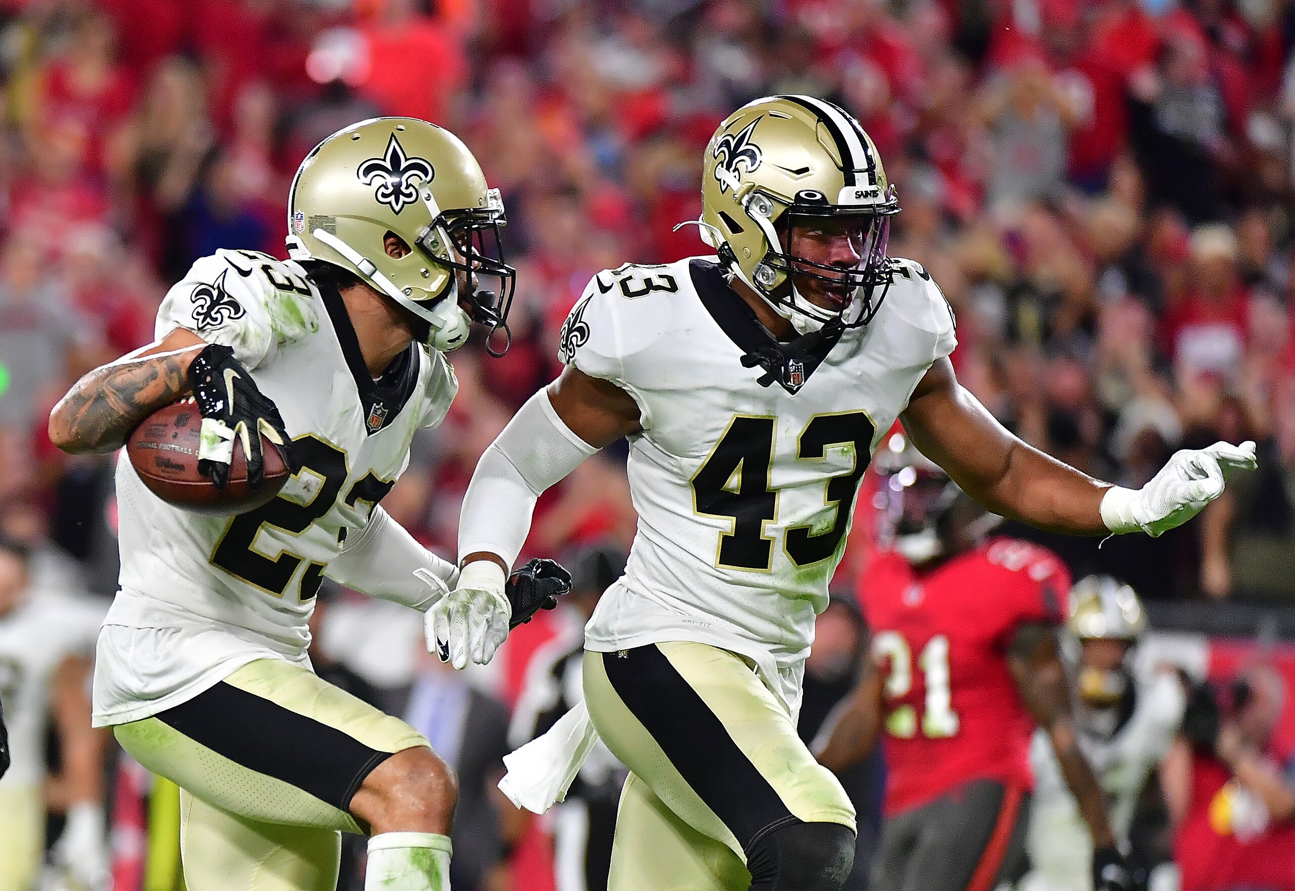 TAMPA, FLORIDA - DECEMBER 19:   Marshon Lattimore #23 and Marcus Williams #43 of the New Orleans Saints celebrate after a fumble recovery during the 3rd quarter of the game against the Tampa Bay Buccaneers at Raymond James Stadium on December 19, 2021 in Tampa, Florida. (Photo by Julio Aguilar/Getty Images)