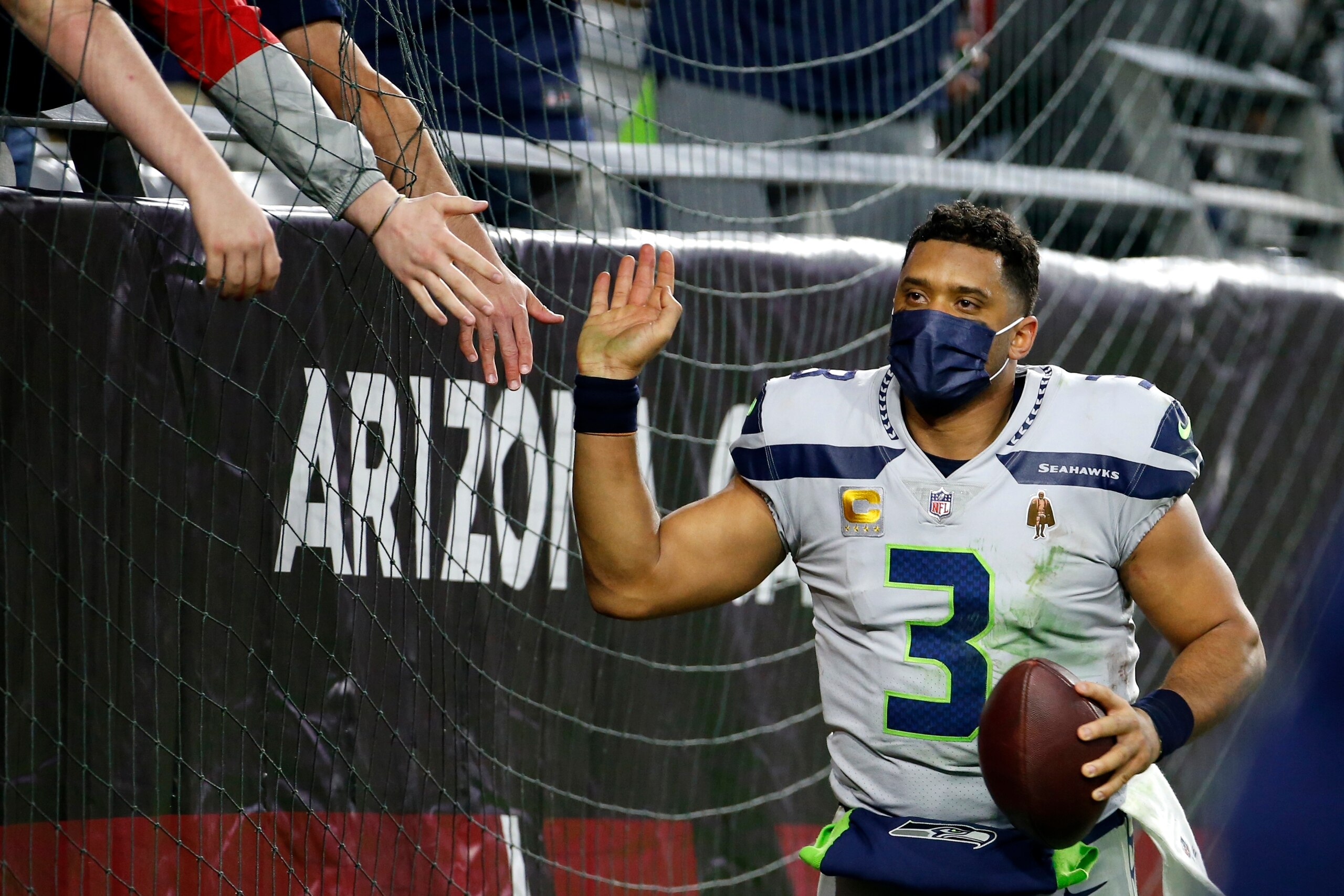 Seattle Seahawks quarterback Russell Wilson gets high-fives from fans after the Seahawks defeated the Arizona Cardinals after an NFL football game Sunday, Jan. 9, 2022, in Glendale, Ariz. The Seahawks won 38-30. (AP Photo/Ralph Freso)