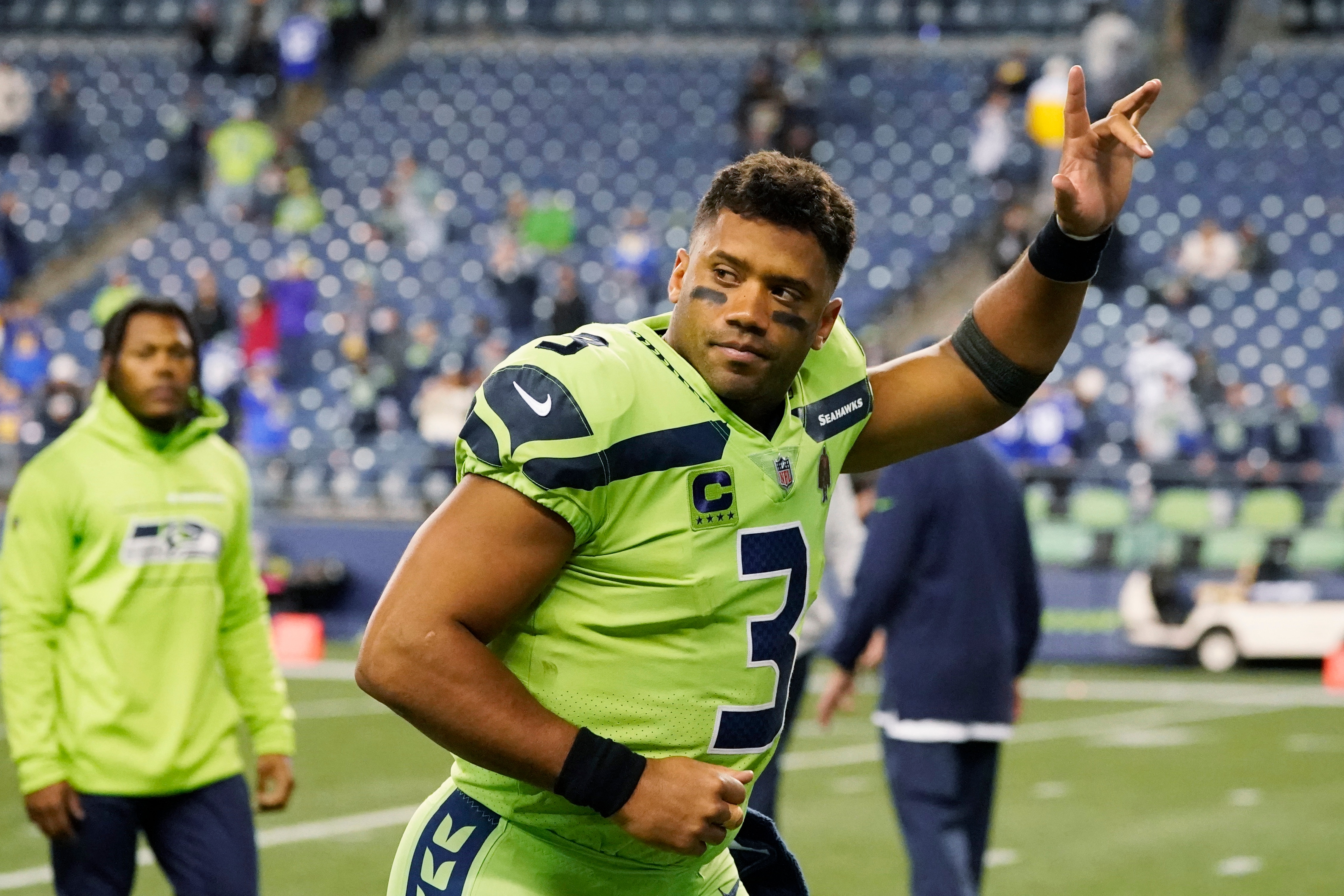 FILE - Seattle Seahawks quarterback Russell Wilson waves to fans as he leaves the field after an NFL football game against the Los Angeles Rams, Thursday, Oct. 7, 2021, in Seattle. The Seattle Seahawks have agreed to trade nine-time Pro Bowl quarterback Russell Wilson to the Denver Broncos for a massive haul of draft picks and players, two people familiar with the negotiations confirmed to The Associated Press on Tuesday, March 8, 2022. The people spoke on condition of anonymity because the blockbuster trade, which is pending Wilson passing a physical, can't become official until the start of the new league year on March 16. (AP Photo/Elaine Thompson, File)