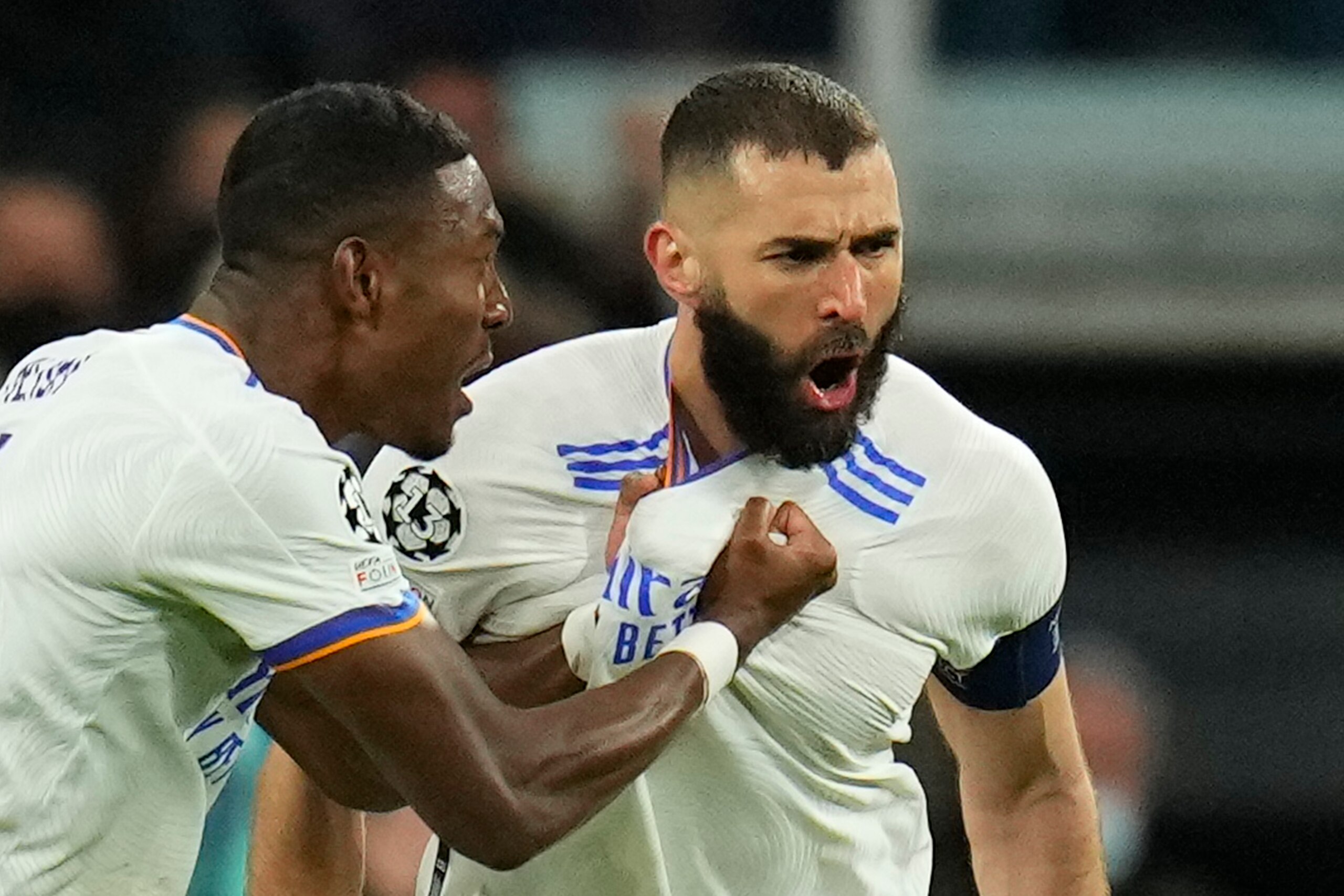 Real Madrid's David Alaba celebrates with Karim Benzema, right, who scored his side's first goal during the Champions League, round of 16, second leg soccer match between Real Madrid and Paris Saint-Germain at the Santiago Bernabeu stadium in Madrid, Spain, Wednesday, March 9, 2022. (AP Photo/Manu Fernandez)