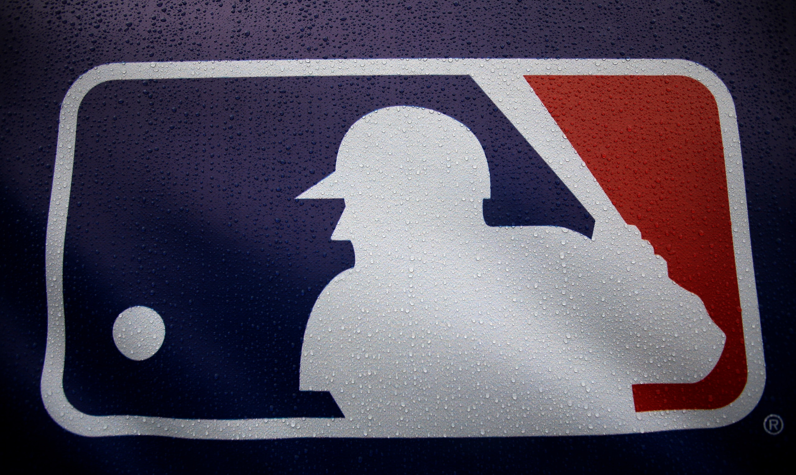 Rain drops cover the Major League Baseball logo before the start of Game 3 of the American League baseball championship series between the Baltimore Orioles and the Kansas City Royals Monday, Oct. 13, 2014, in Kansas City, Mo. The Royals lead the series 2-0. (AP Photo/Matt Slocum )