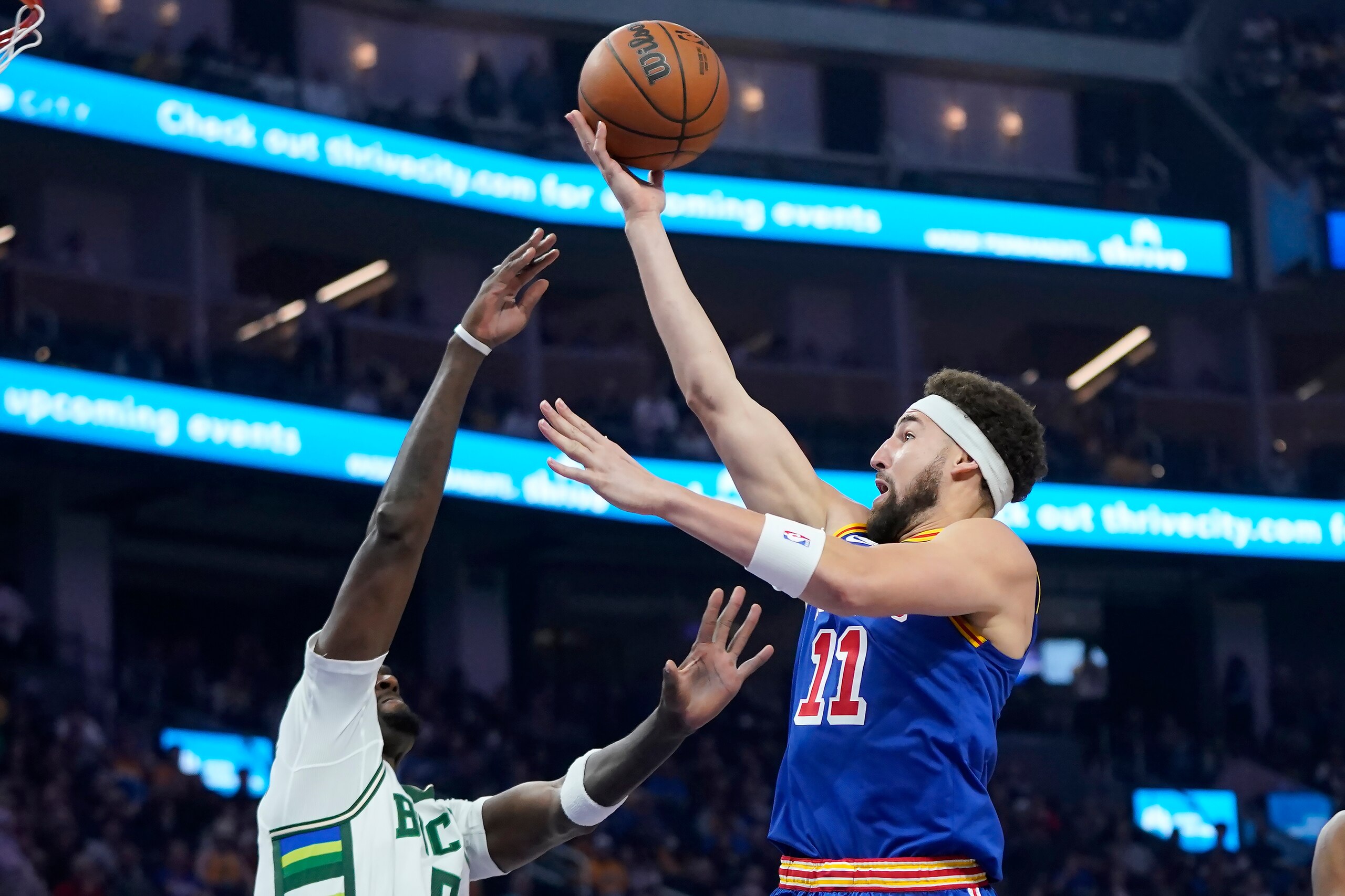 Golden State Warriors guard Klay Thompson (11) shoots against Milwaukee Bucks center Bobby Portis Jr. during the first half of an NBA basketball game in San Francisco, Saturday, March 12, 2022. (AP Photo/Jeff Chiu)