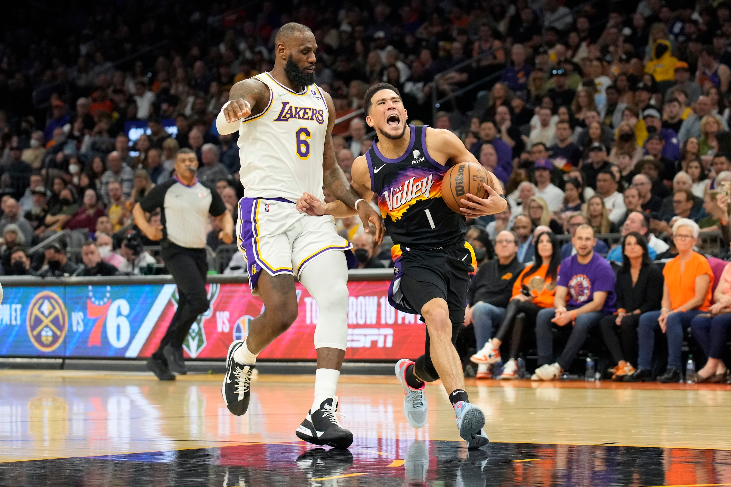 Phoenix Suns guard Devin Booker (1) is pressured by Los Angeles Lakers forward LeBron James during the second half of an NBA basketball game, Sunday, March 13, 2022, in Phoenix. (AP Photo/Rick Scuteri) Phoenix Suns guard Devin Booker (1) is pressured by Los Angeles Lakers forward LeBron James during the second half of an NBA basketball game, Sunday, March 13, 2022, in Phoenix. (AP Photo/Rick Scuteri)