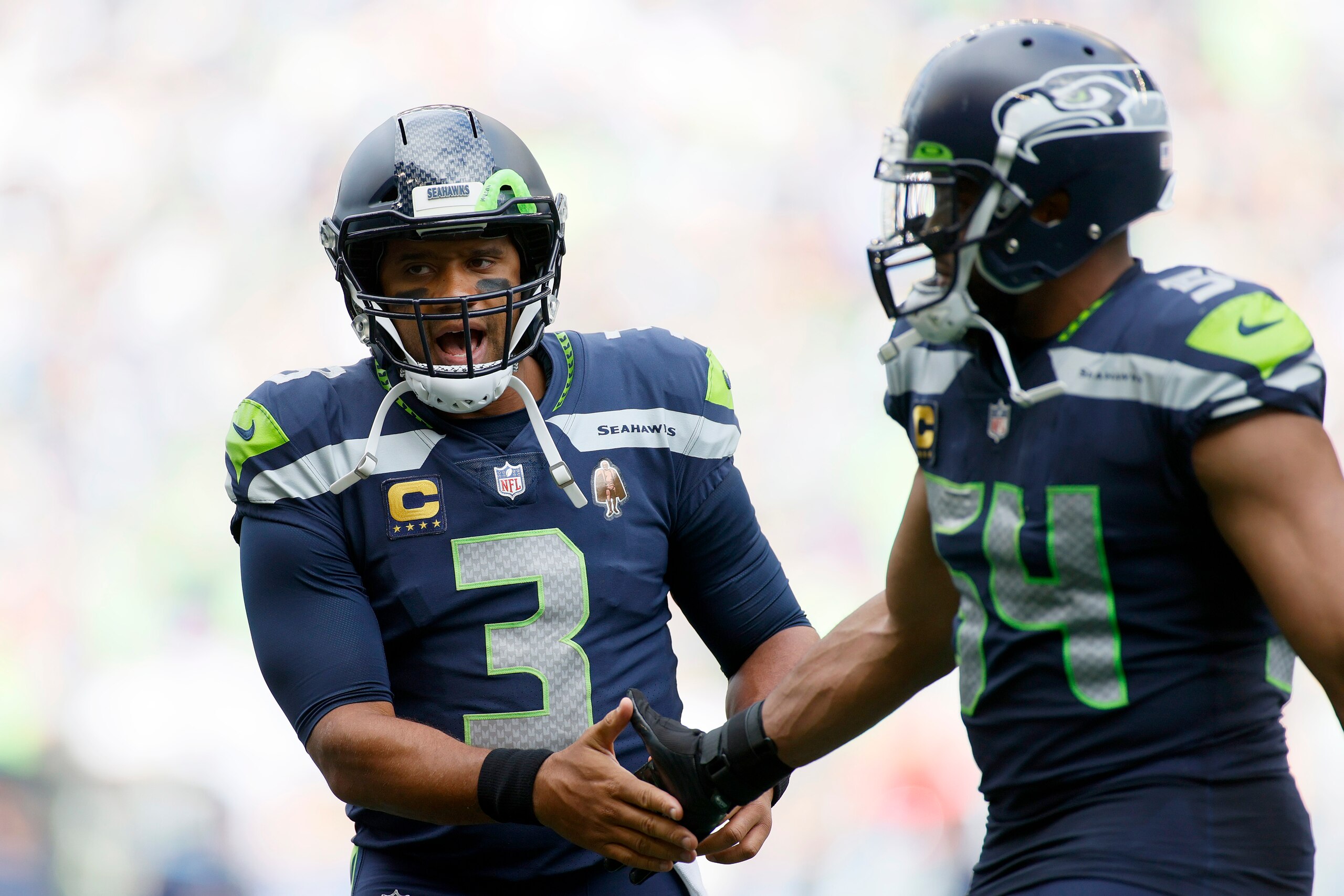 SEATTLE, WASHINGTON - SEPTEMBER 19: Russell Wilson #3 and Bobby Wagner #54 of the Seattle Seahawks react during the fourth quarter against the Tennessee Titans at Lumen Field on September 19, 2021 in Seattle, Washington. (Photo by Steph Chambers/Getty Images)
