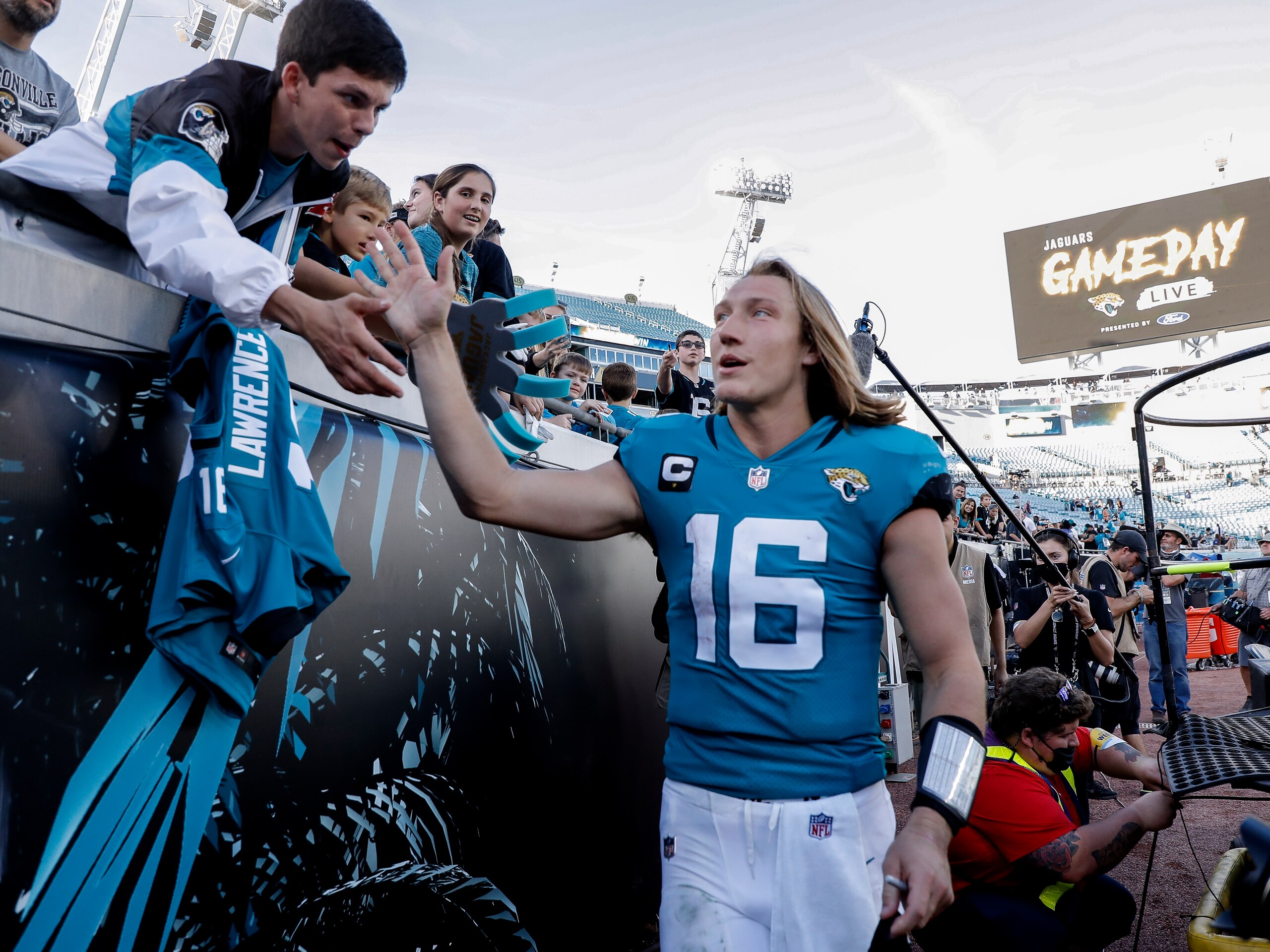 JACKSONVILLE, FL - JANUARY 9:  Quarterback Trevor Lawrence #16 of the Jacksonville Jaguars celebrates with fans after the game against the Indianapolis Colts at TIAA Bank Field on January 9, 2022 in Jacksonville, Florida. The Jaguars won 26 -11. (Photo by Don Juan Moore/Getty Images)