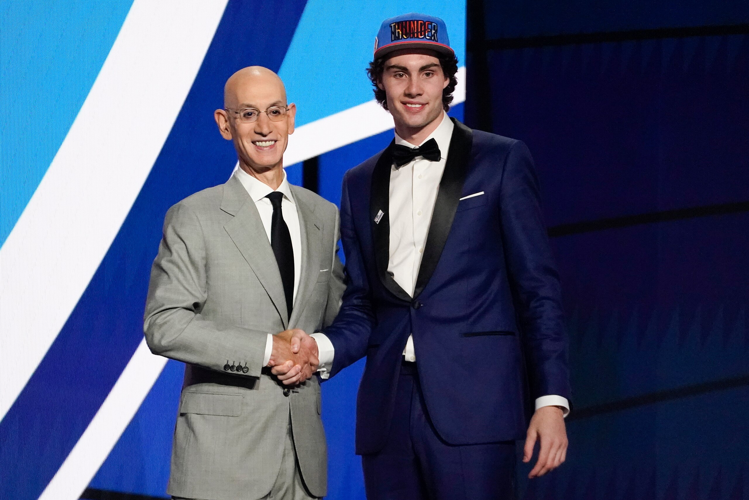 CORRECTS SPELLING TO GIDDEY, INSTEAD OF GIDDY - CORRECTS TEAM TO OKLAHOMA CITY THUNDER, INSTEAD OF GOLDEN STATE WARRIORS - Josh Giddey, right, poses for a photo with NBA Commissioner Adam Silver after being selected sixth overall by the Oklahoma City Thunder during the NBA basketball draft, Thursday, July 29, 2021, in New York. (AP Photo/Corey Sipkin)