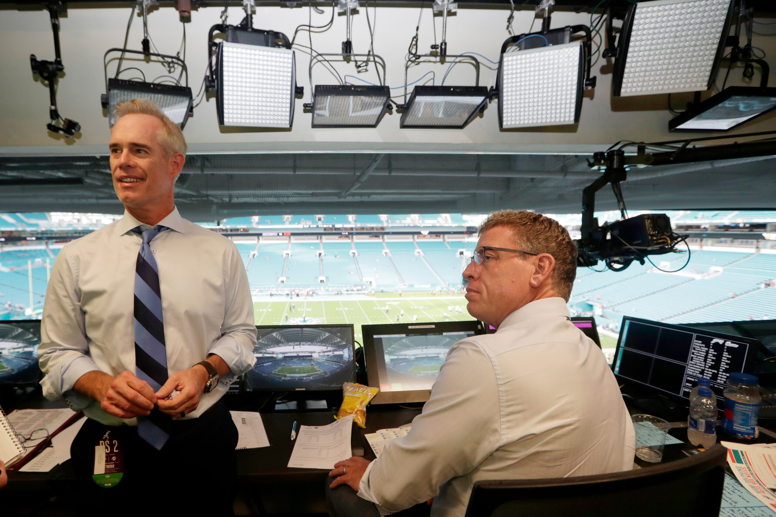 FILE - In this Aug. 23, 2019, file photo, Fox Sports play-by-play announcer Joe Buck, left, and analyst Troy Aikman, right, work in the broadcast booth before a preseason NFL football game between the Miami Dolphins and Jacksonville Jaguars in Miami Gardens, Fla. Chris Myers and Erin Andrews will be doing a little bit of everything on the sidelines for Fox's broadcast of Super Bowl 54. Not only will they be filing reports, but will be the eyes and ears for the production truck as well as Joe Buck and Troy Aikman in the booth. (AP Photo/Lynne Sladky, File)