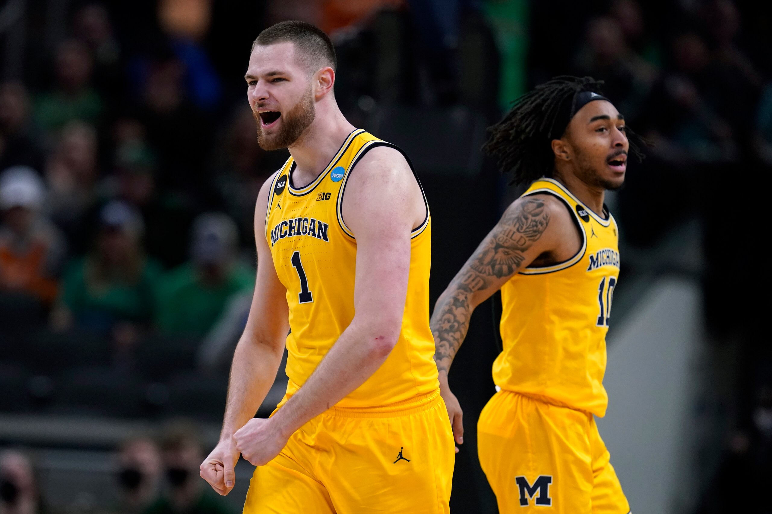 Michigan center Hunter Dickinson (1) celebrates with teammate Frankie Collins, right, during the second half of a college basketball game against Colorado State in the first round of the NCAA tournament in Indianapolis, Thursday, March 17, 2022. (AP Photo/Michael Conroy)
