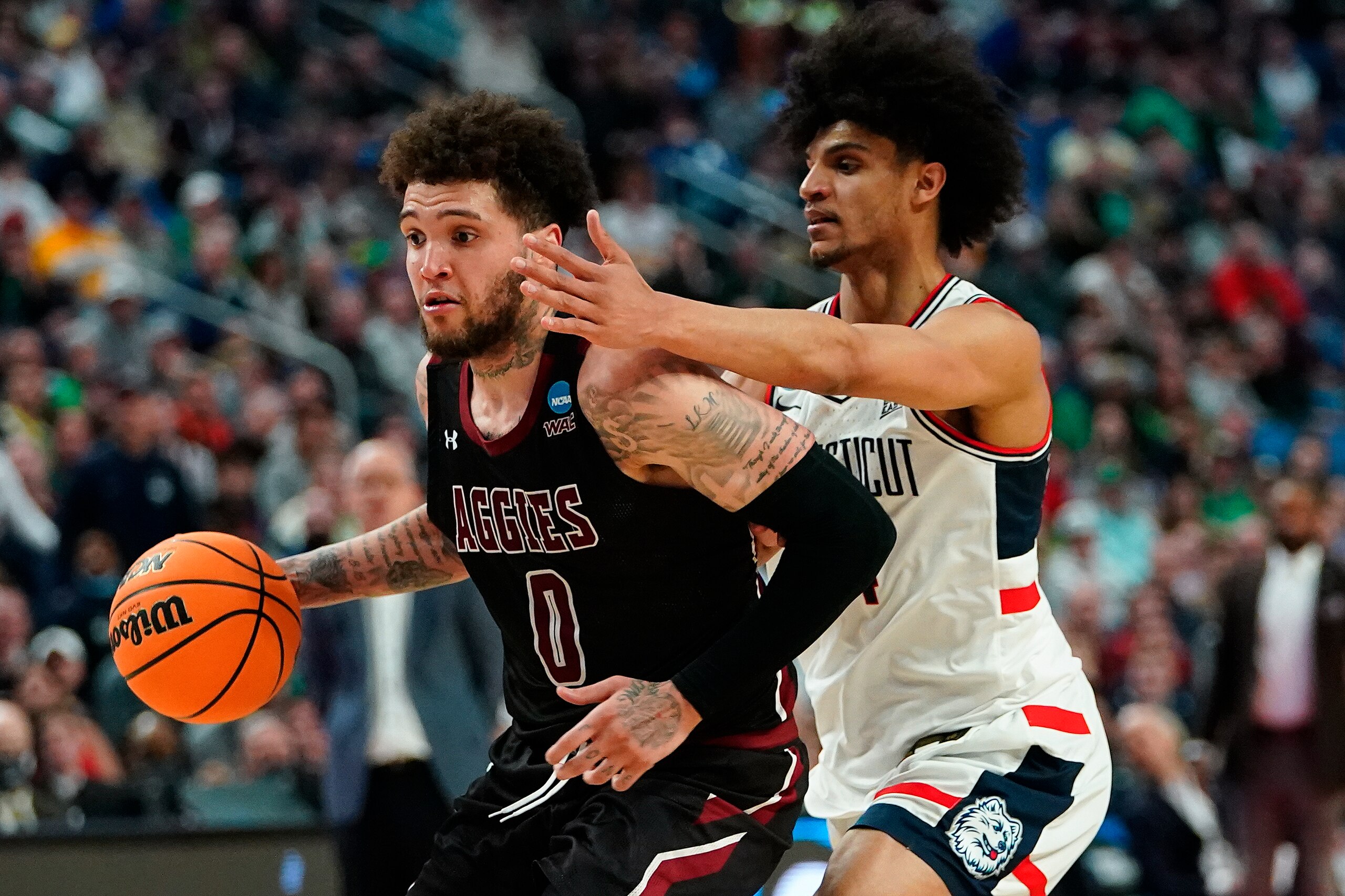 New Mexico State guard Teddy Allen (0) drives against Connecticut guard Andre Jackson (44) during the second half of a college basketball game in the first round of the NCAA men's tournament, Thursday, March 17, 2022, in Buffalo, N.Y. (AP Photo/Frank Franklin II)