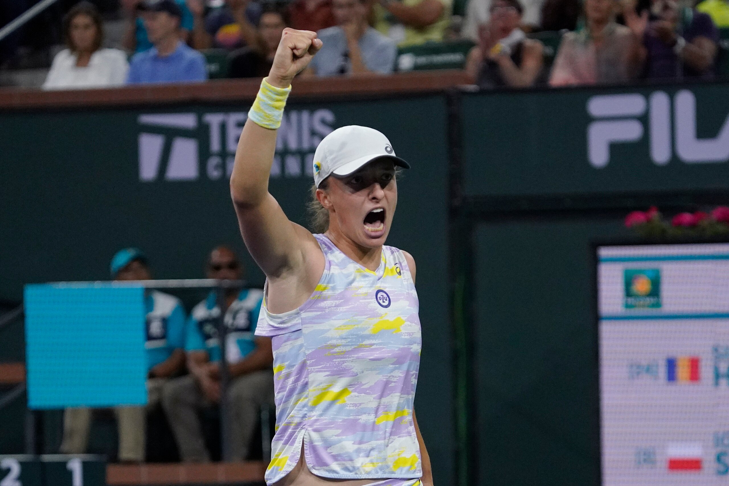 Iga Swiatek, of Poland, reacts after winning a game during her women's singles semifinals match against Simona Halep, of Romania, at the BNP Paribas Open tennis tournament Friday, March 18, 2022, in Indian Wells, Calif. (AP Photo/Mark J. Terrill)
