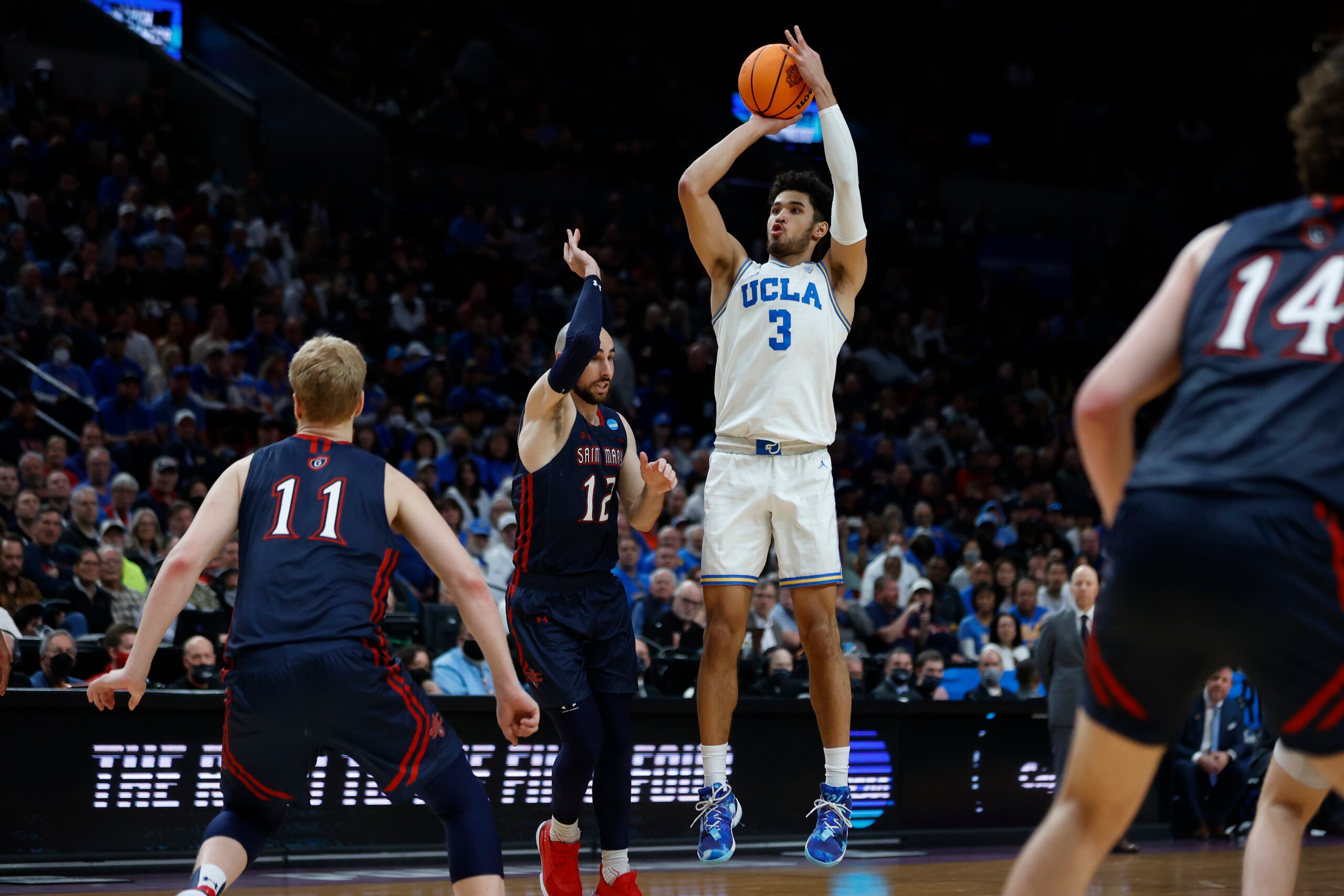 UCLA guard guard Johnny Juzang (3) shoots above St. Mary's guard Tommy Kuhse (12) during the first half of a second-round NCAA college basketball tournament game, Saturday, March 19, 2022, in Portland, Ore. (AP Photo/Craig Mitchelldyer)