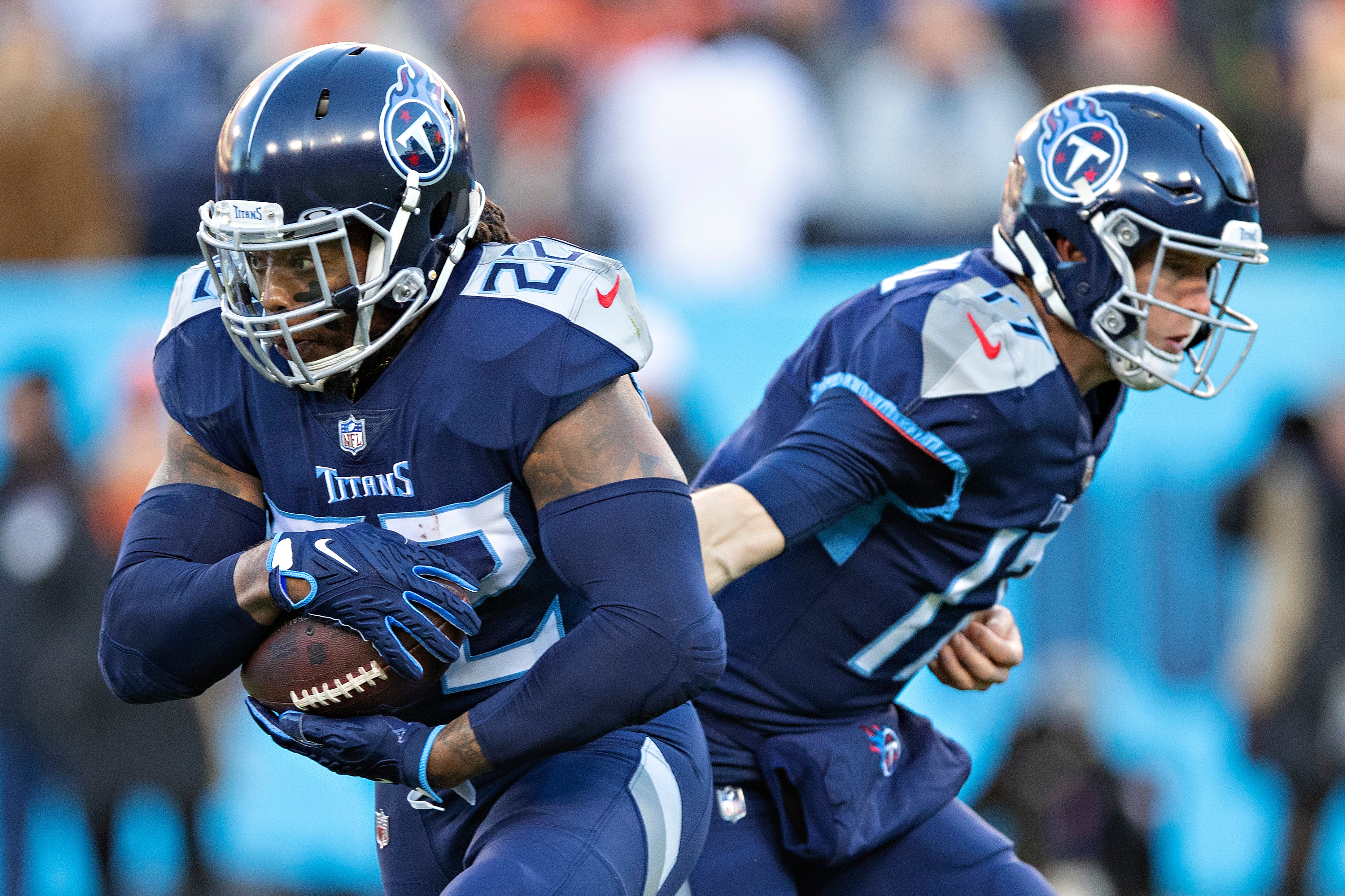 NASHVILLE, TENNESSEE - JANUARY 22: Derrick Henry #22 takes a hand off from Ryan Tannehill #17 of the Tennessee Titans during a game against the Cincinnati Bengals in the AFC Divisional Playoff game at Nissan Stadium on January 22, 2022 in Nashville, Tennessee. The Bengals defeated the Titans 19-16.  (Photo by Wesley Hitt/Getty Images)
