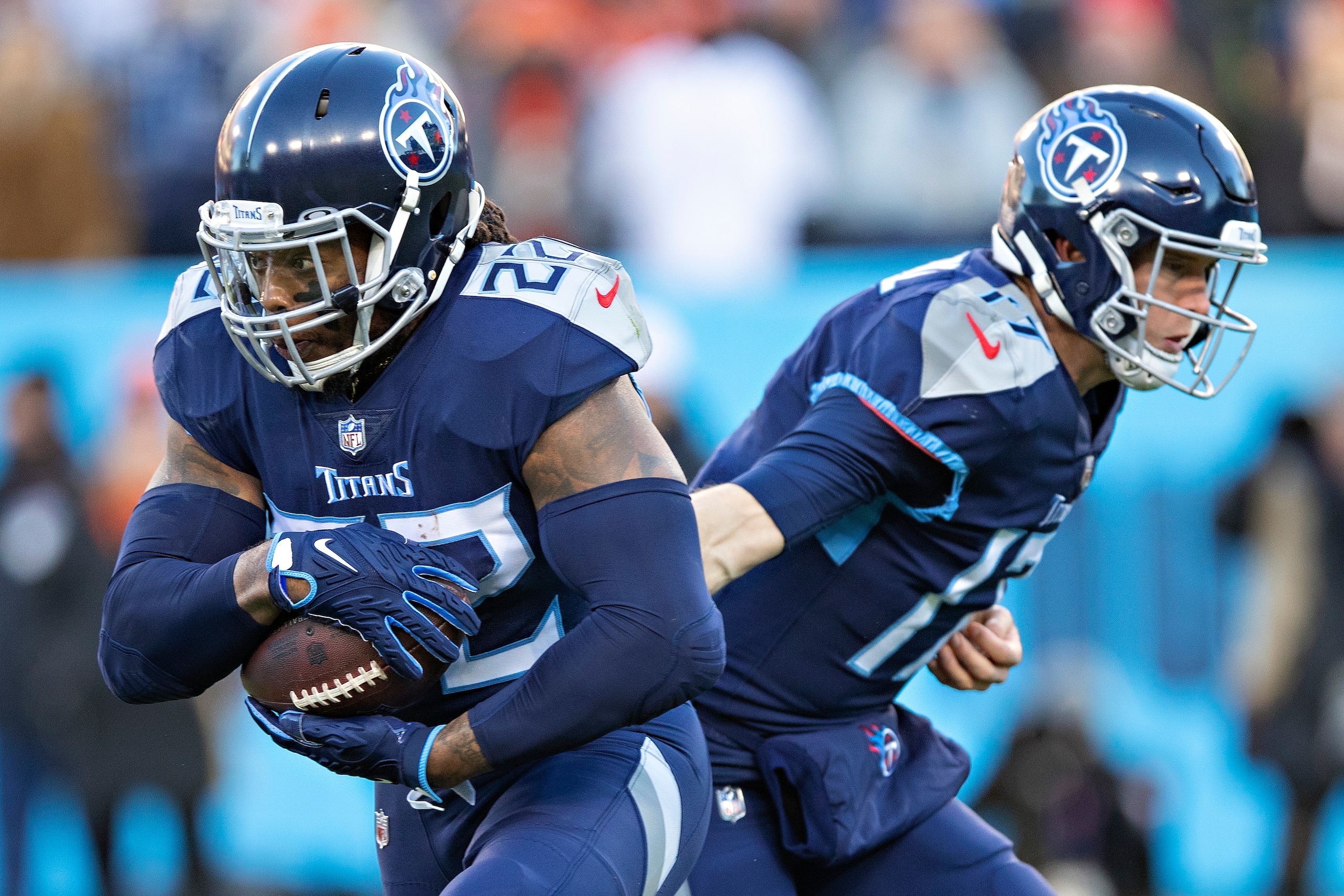NASHVILLE, TENNESSEE - JANUARY 22: Derrick Henry #22 takes a hand off from Ryan Tannehill #17 of the Tennessee Titans during a game against the Cincinnati Bengals in the AFC Divisional Playoff game at Nissan Stadium on January 22, 2022 in Nashville, Tennessee. The Bengals defeated the Titans 19-16.  (Photo by Wesley Hitt/Getty Images)