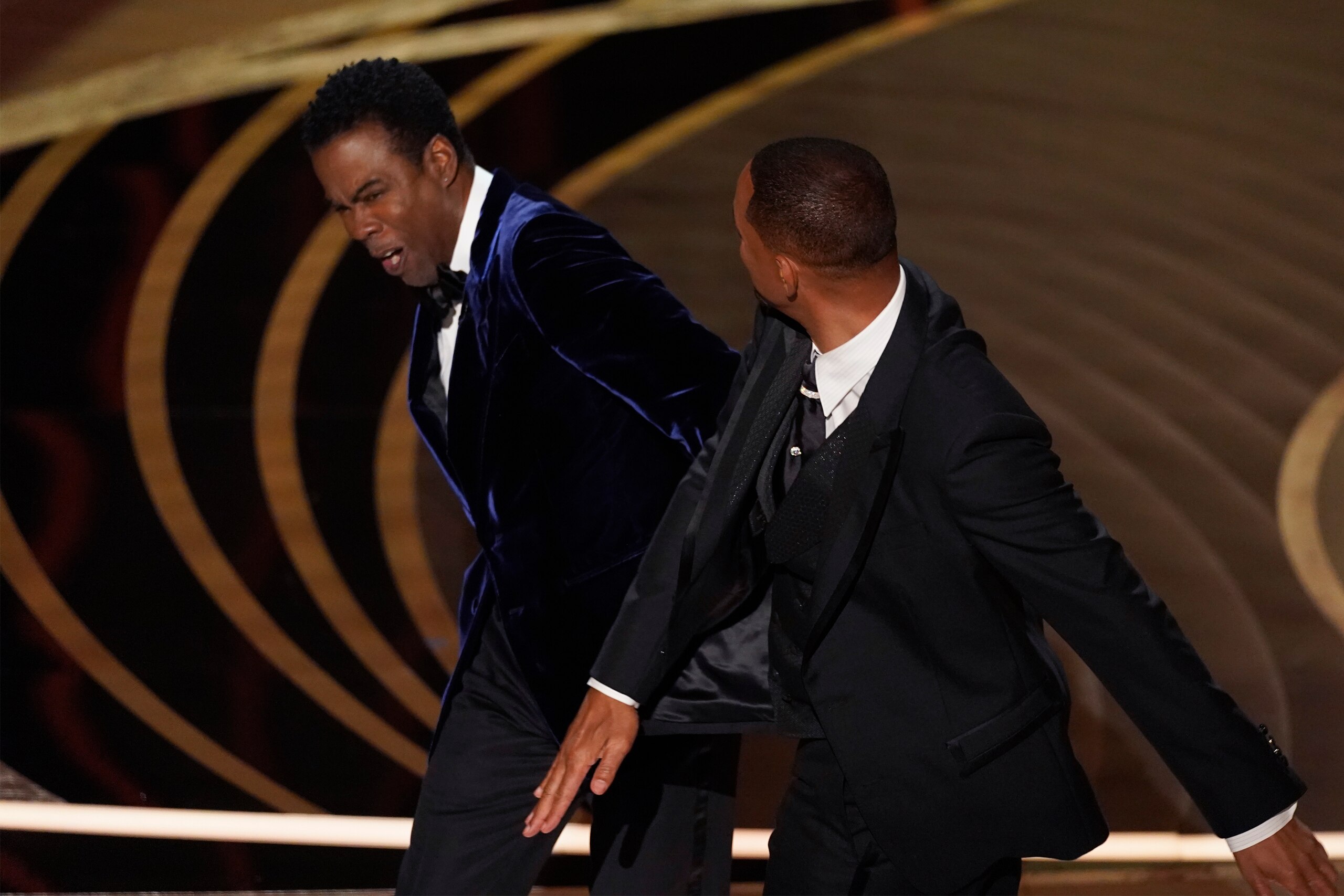 Will Smith, right, hits presenter Chris Rock on stage while presenting the award for best documentary feature at the Oscars on Sunday, March 27, 2022, at the Dolby Theatre in Los Angeles. (AP Photo/Chris Pizzello) Will Smith, right, hits presenter Chris Rock on stage while presenting the award for best documentary feature at the Oscars on Sunday, March 27, 2022, at the Dolby Theatre in Los Angeles. (AP Photo/Chris Pizzello)