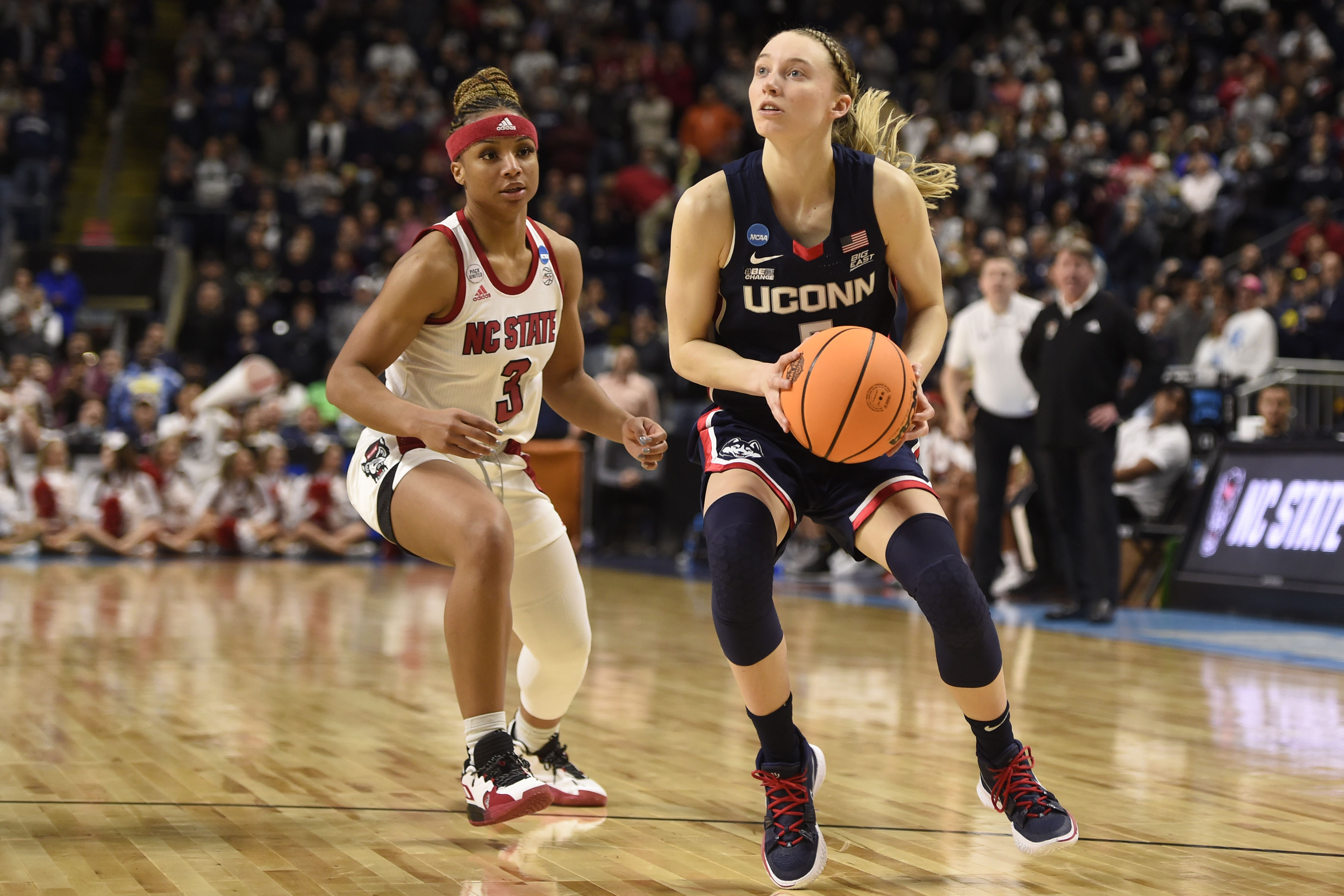BRIDGEPORT, CT - MARCH 28: Paige Bueckers #5 of the Connecticut Huskies drives past Kai Crutchfield #3 of the N.C. State Wolfpack during the Elite Eight round of the 2022 NCAA Womens Basketball Tournament held at Total Mortgage Arena at Harbor Yard on March 28, 2022 in Bridgeport, Connecticut. (Photo by Khoi Ton/NCAA Photos via Getty Images)