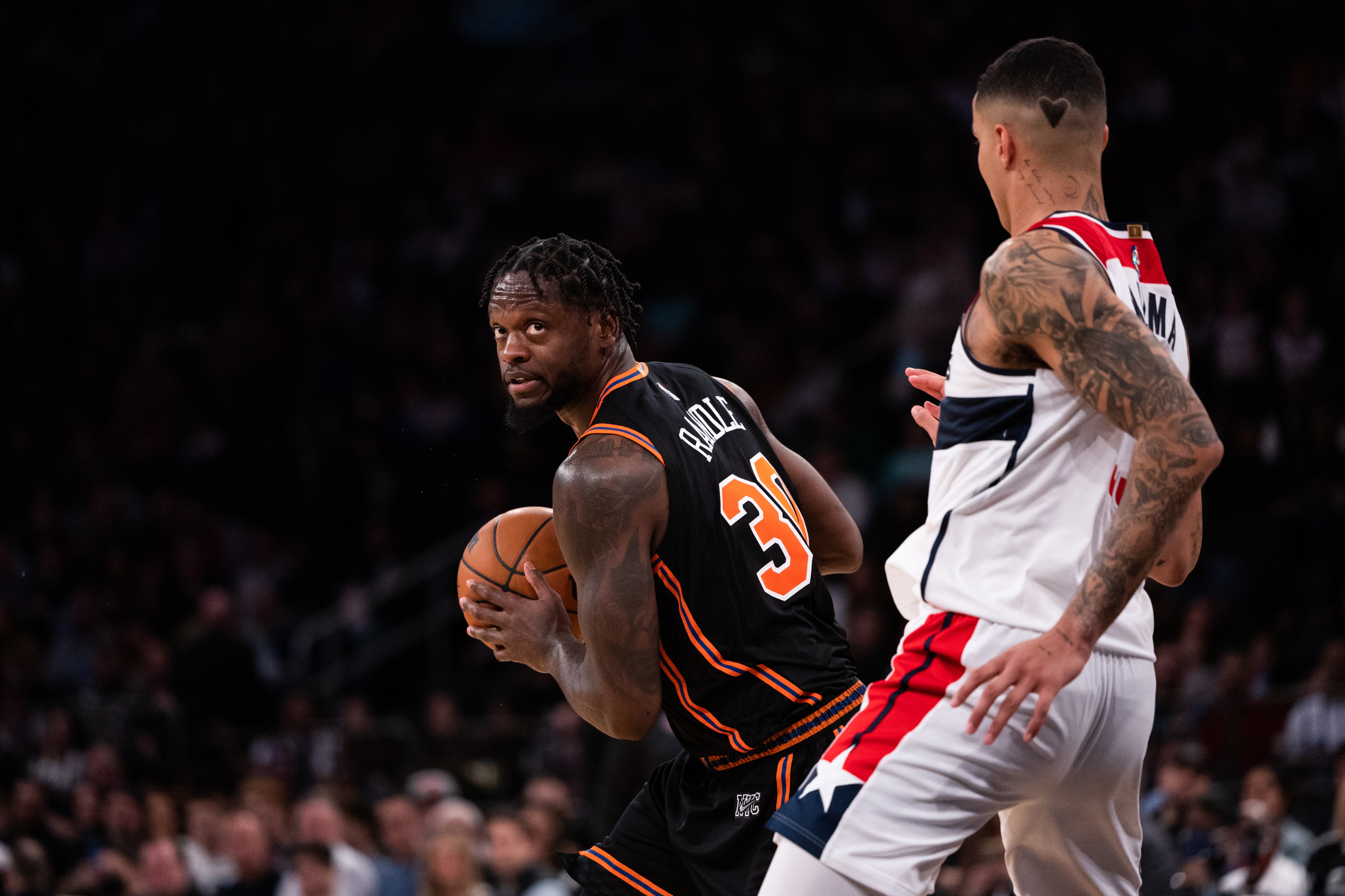 NEW YORK, NEW YORK - MARCH 18: Julius Randle #30 of the New York Knicks is guarded by Kyle Kuzma #33 of the Washington Wizards during the second half of the game at Madison Square Garden on March 18, 2022 in New York City. NOTE TO USER: User expressly acknowledges and agrees that, by downloading and or using this photograph, User is consenting to the terms and conditions of the Getty Images License Agreement. (Photo by Dustin Satloff/Getty Images)
